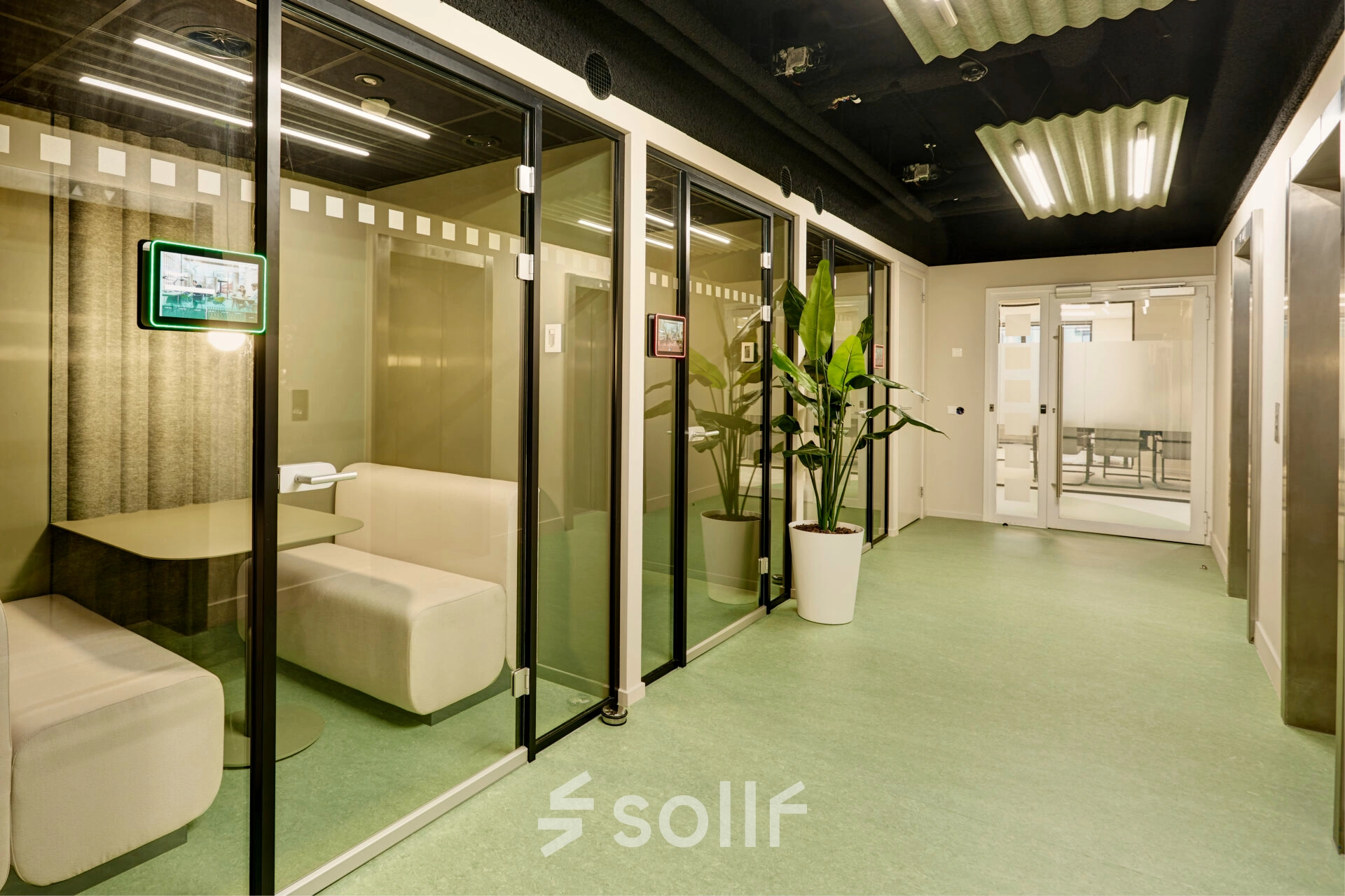 Modern office space at Weena 335, Rotterdam Center, featuring glass-enclosed booths ideal for meetings or independent work, available for rent.