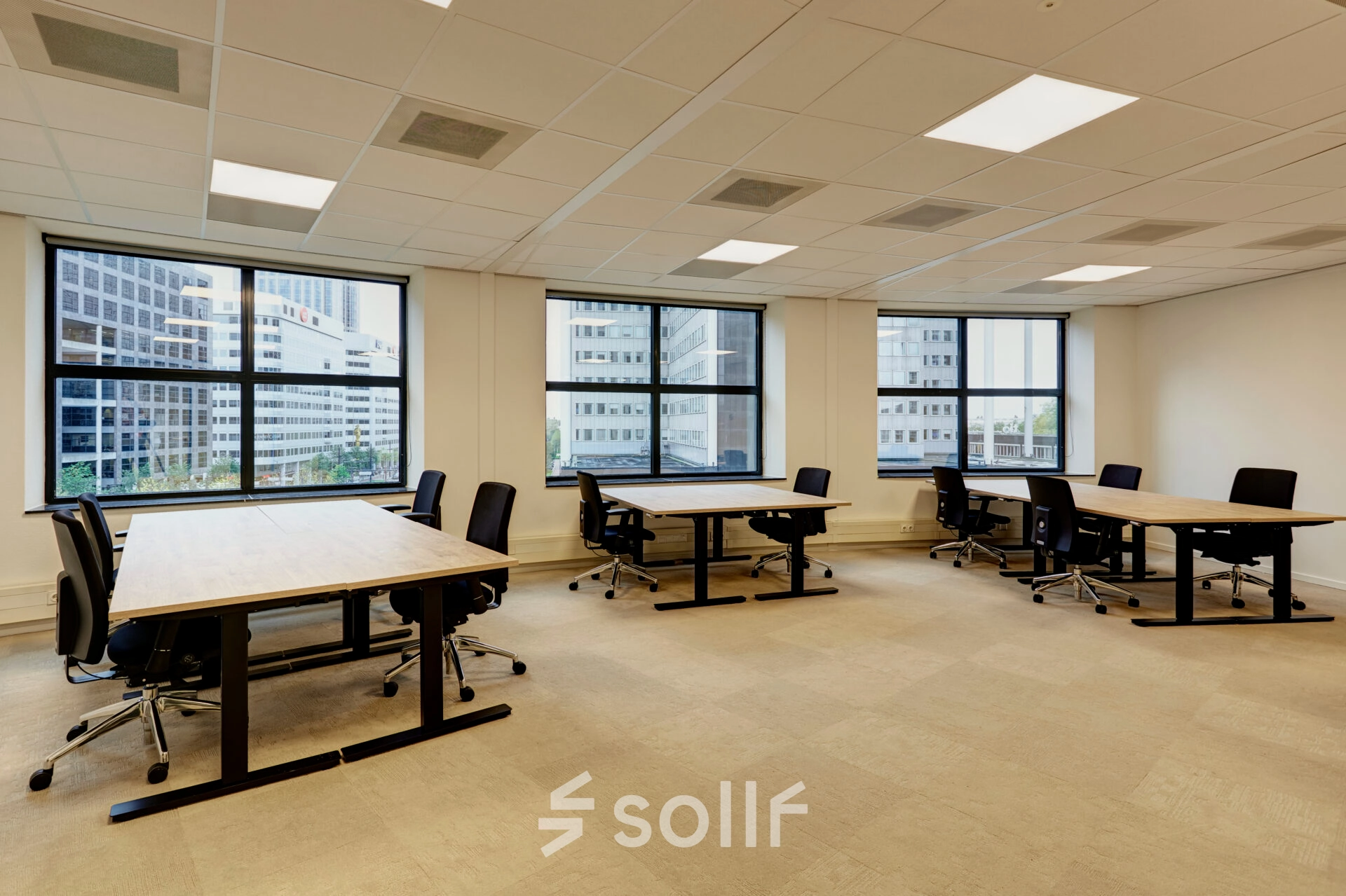 Bright office space at Weena 335, Rotterdam Center, featuring large windows and modern furniture. Ideal for those looking to rent office space with multiple desks and chairs.