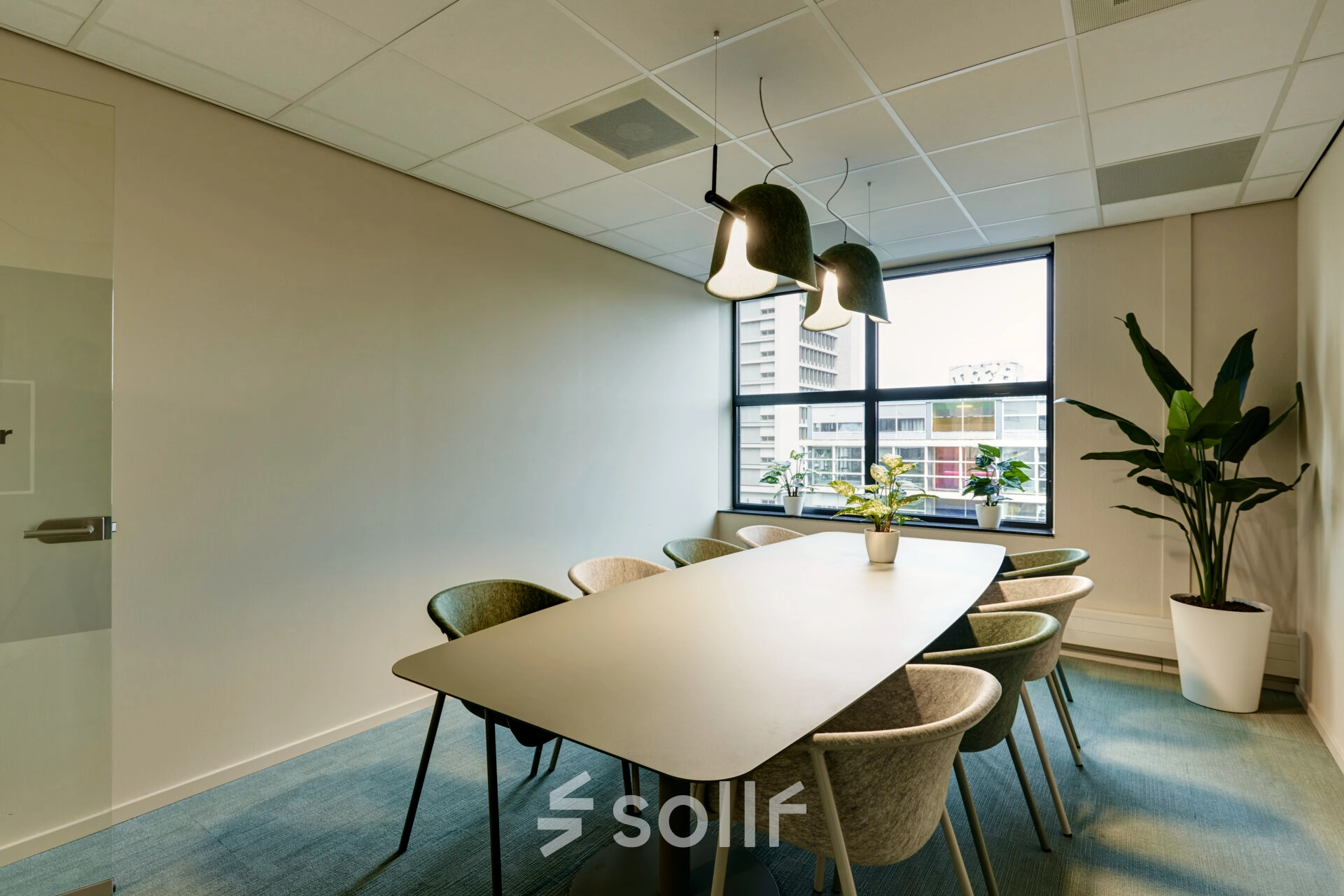 Bright conference room available for office space rental at Weena 335 in Rotterdam Center, featuring a large table, modern chairs, and stylish lighting, perfect for collaborative meetings.
