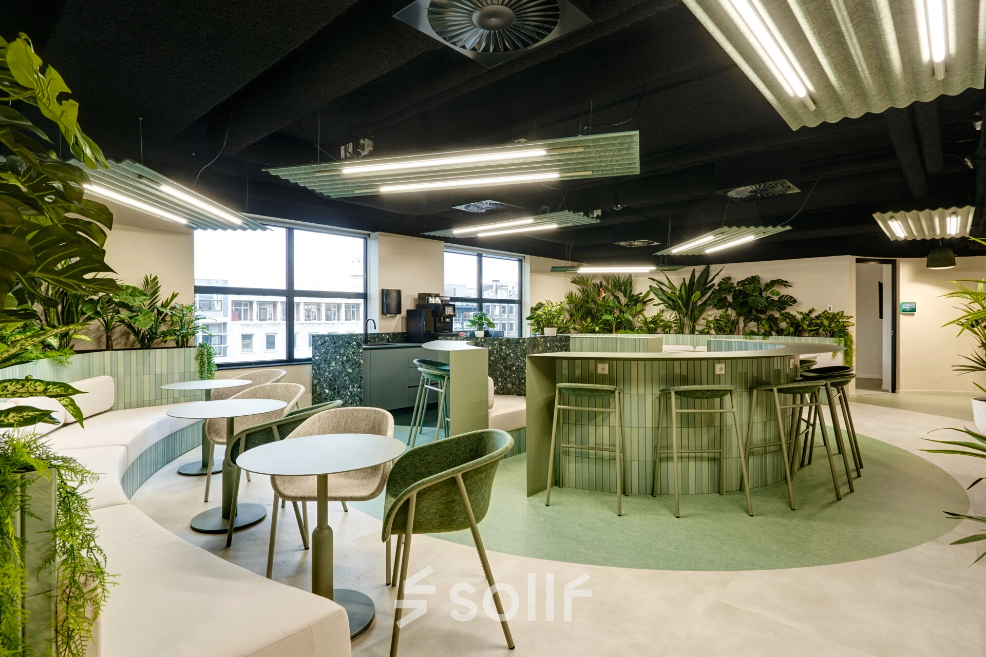 Modern office space with green-themed furnishings at Weena 335, Rotterdam Center, available for rent. Includes seating areas and plants, ideal for informal meetings.