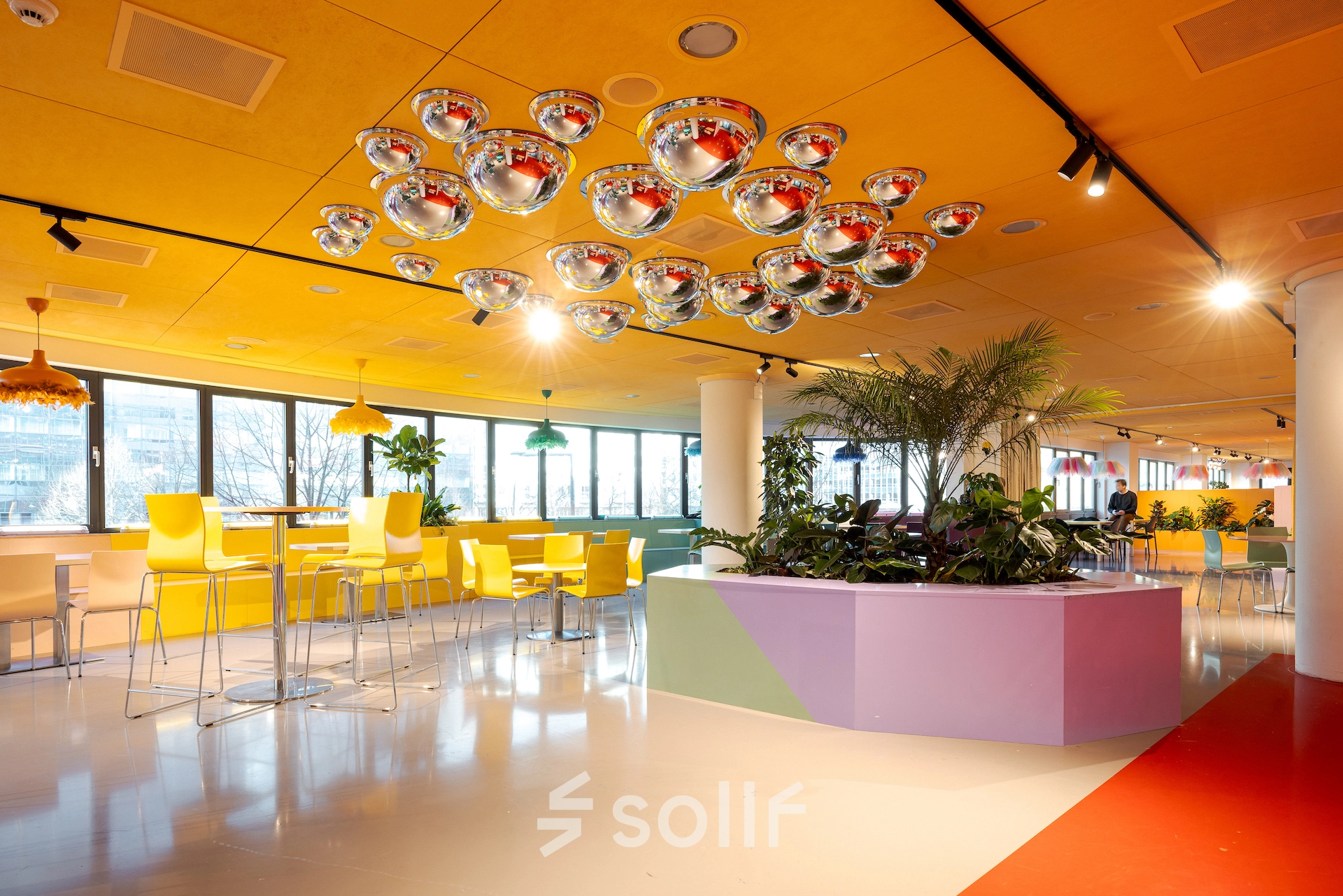 Bright office space to rent at Weena 70, Rotterdam Center, featuring colorful decor, modern furniture, and large windows offering plenty of natural light. Ideal for office space rental.