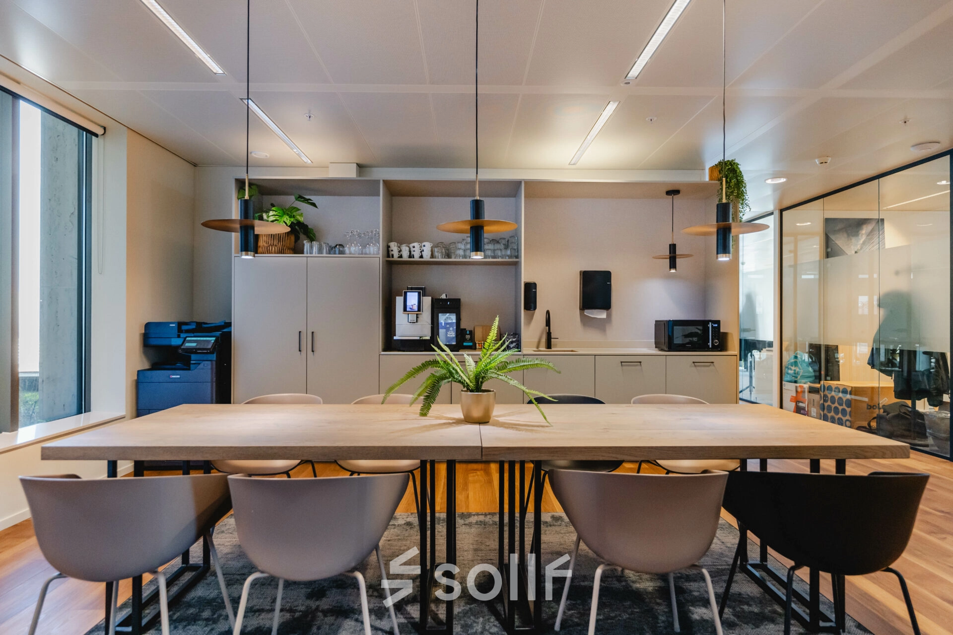 Modern office to rent at Weena 788, Rotterdam Center with furnished workspace, featuring a long table, multiple chairs, cabinets, and plants for office space rental ambiance.