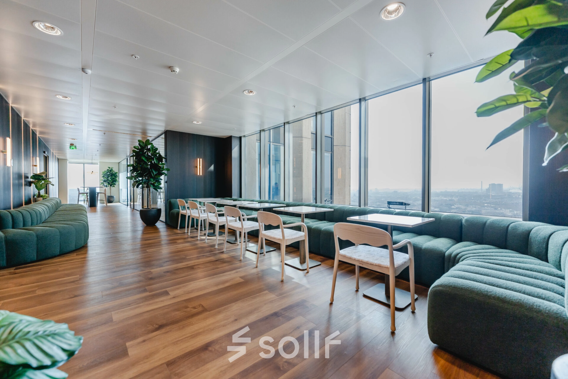 Bright office lounge at Weena 788, Rotterdam Center with modern seating arrangements and large windows, ideal for office space rental.