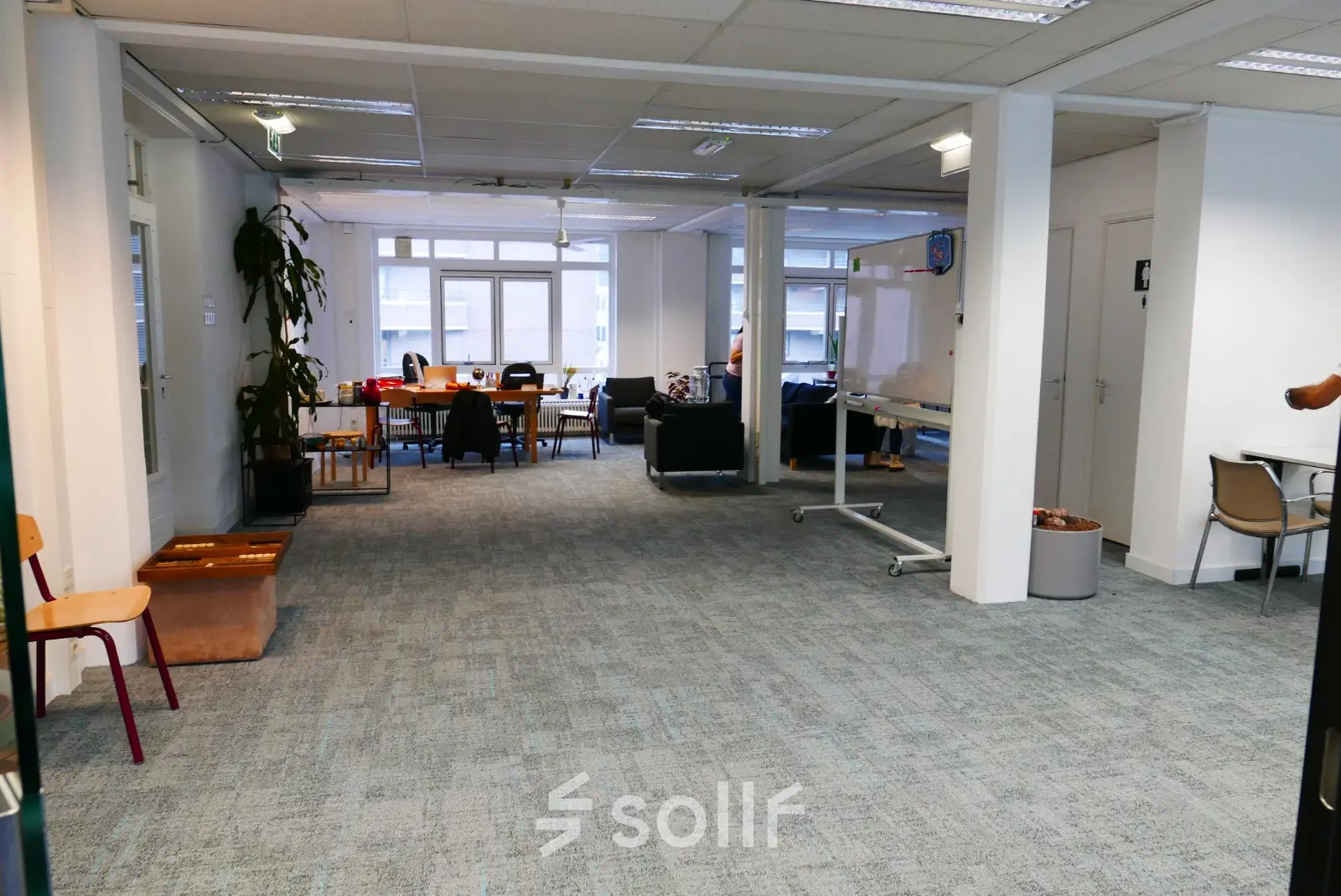 Spacious open floor plan of an office available for rent at Wijnhaven 76 in Rotterdam Center, featuring desks, chairs, and a whiteboard, ideal for collaborative work and meetings.