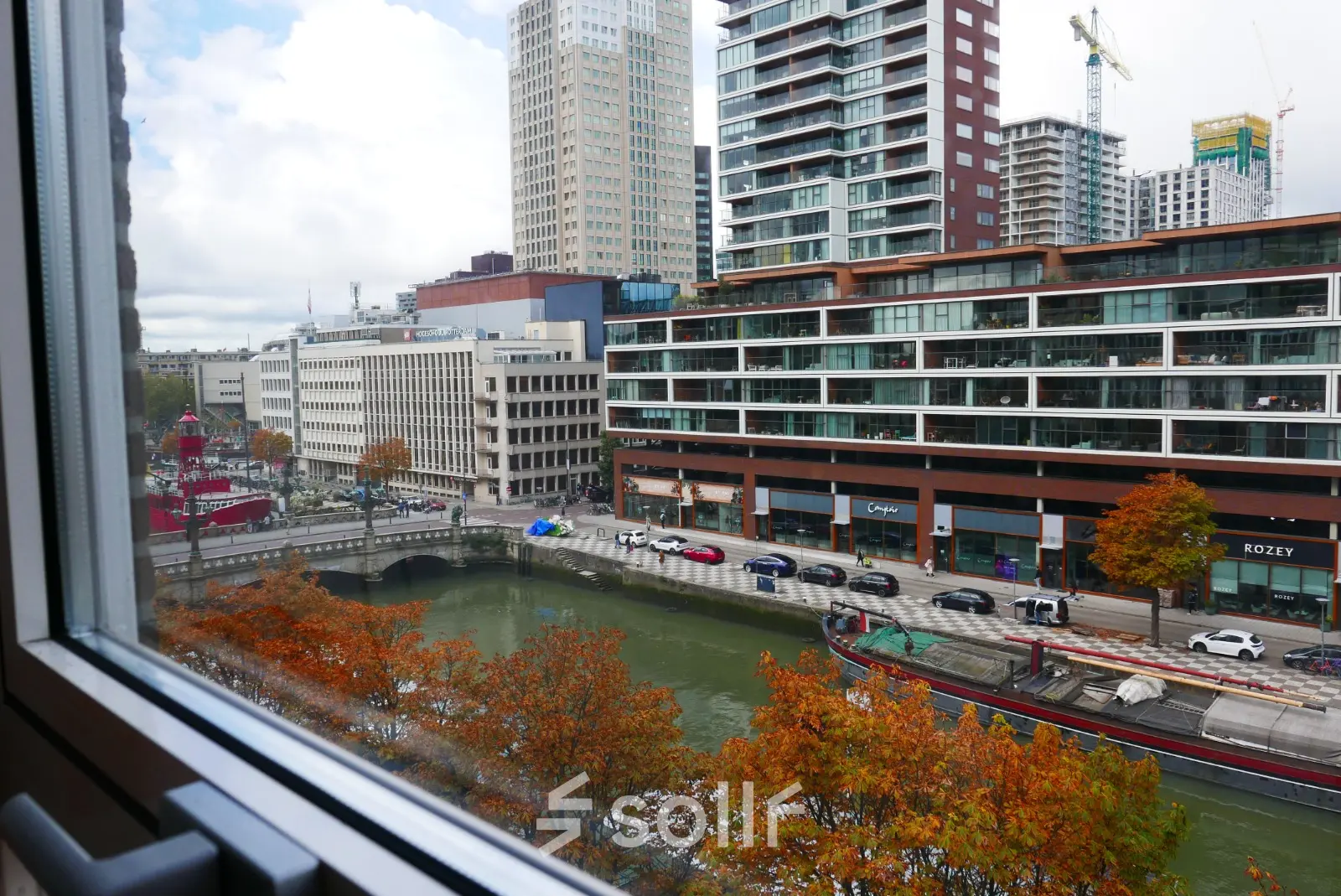 View from an office to rent at Wijnhaven 76 in Rotterdam Center, overlooking modern buildings and a canal.