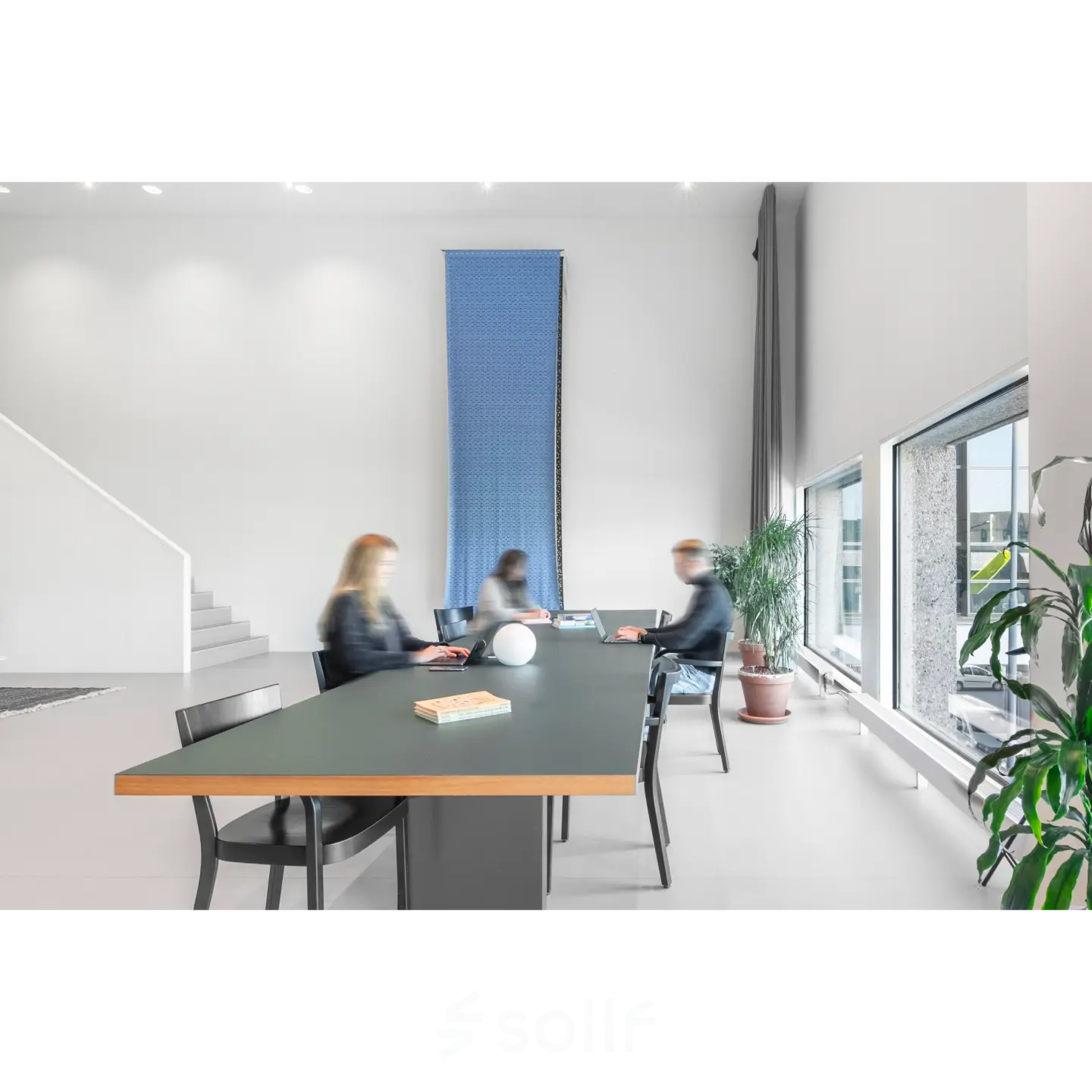 Modern office space rental at Hofplein 20, Rotterdam Central Station, featuring a sleek table with people engaged in business activities.