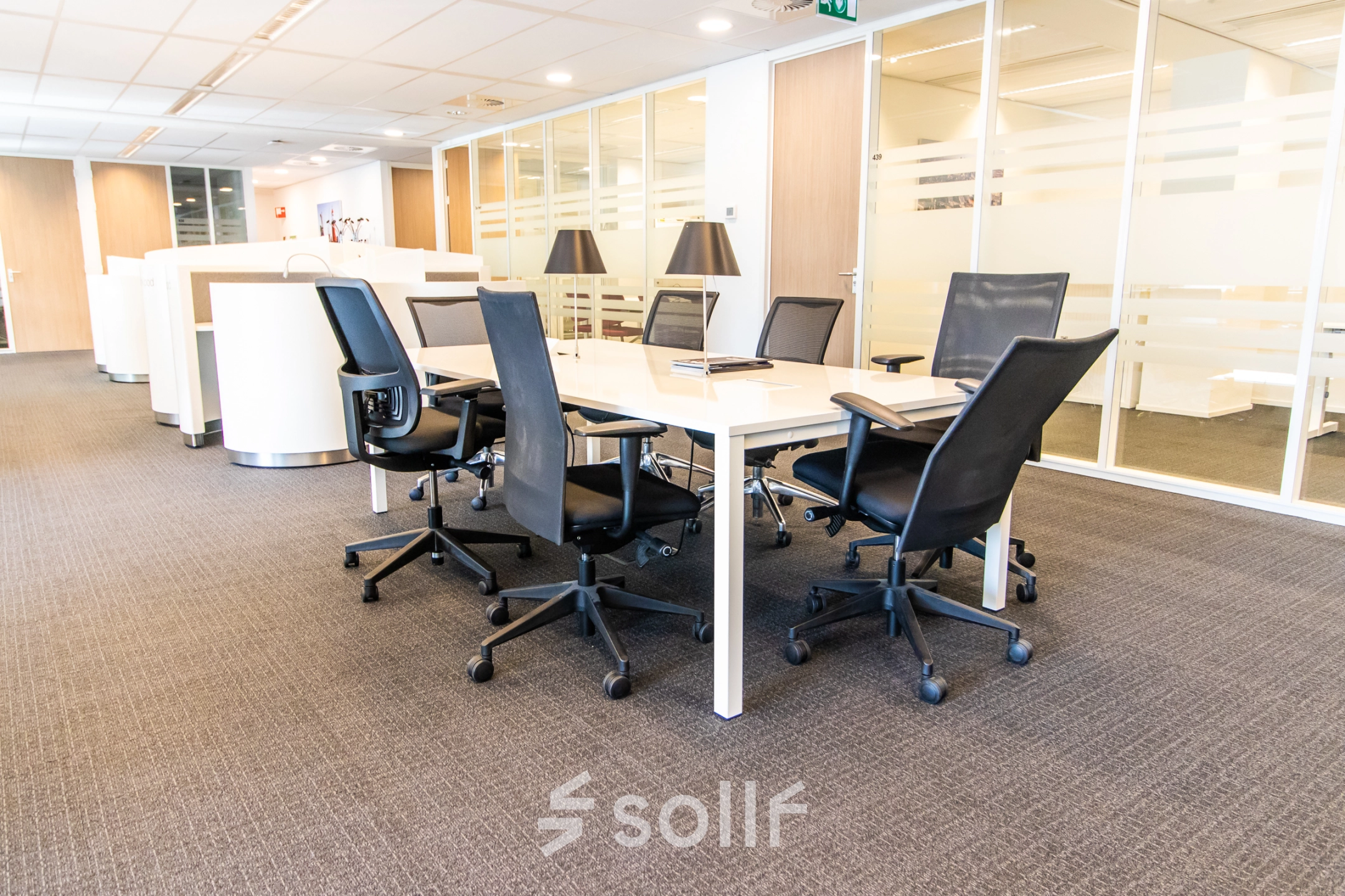 Modern office space rental at Weena-Zuid 130, Rotterdam Central Station featuring a conference table with chairs, ideal for meetings.