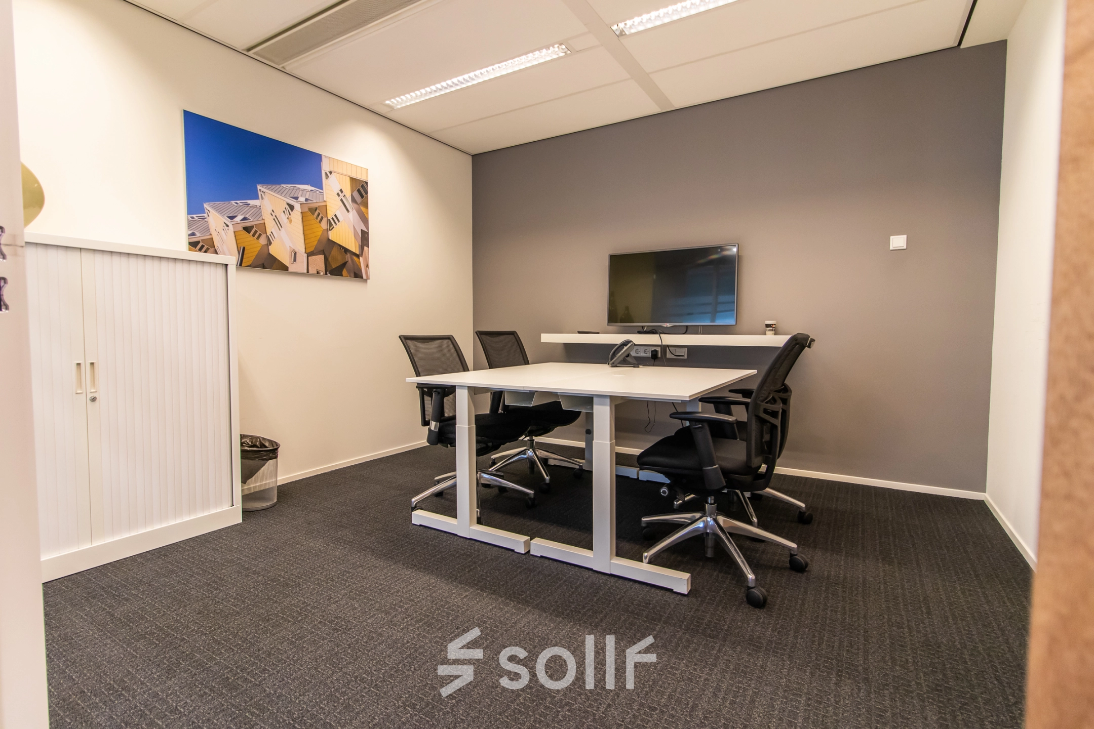 Modern office to rent in Rotterdam Central Station with a meeting table, chairs, and a mounted TV, ideal for office space rental at Weena-Zuid 130.