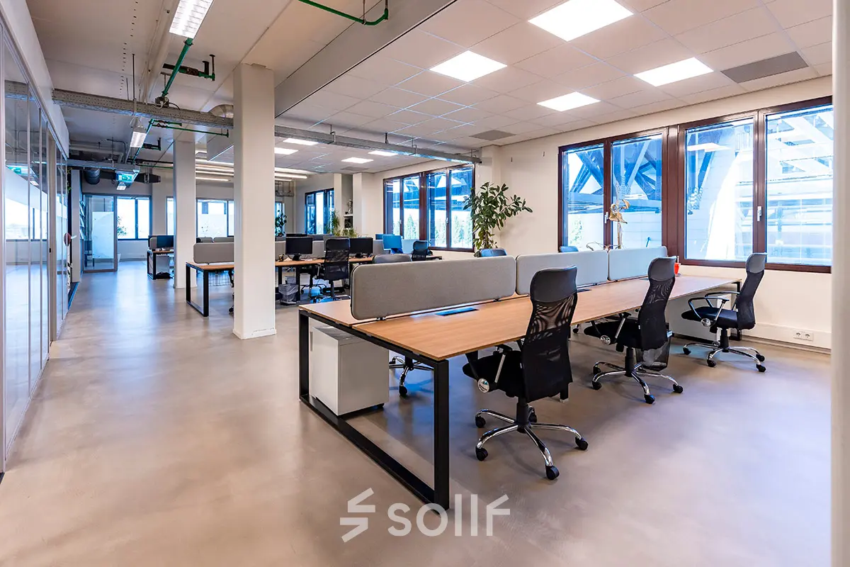 Contemporary office space at Kratonkade 7 - 27 in Rotterdam Delfshaven, featuring rows of modern desks and chairs. Ideal for rent office space needs in an open floorplan design.