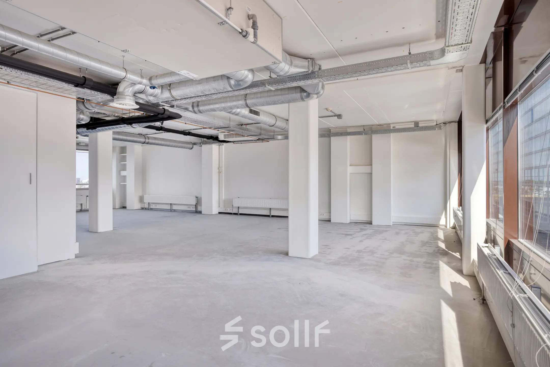 Unfurnished office space available for rent at Kratonkade 7 - 27 in Rotterdam Delfshaven, featuring large windows and industrial exposed ducts.
