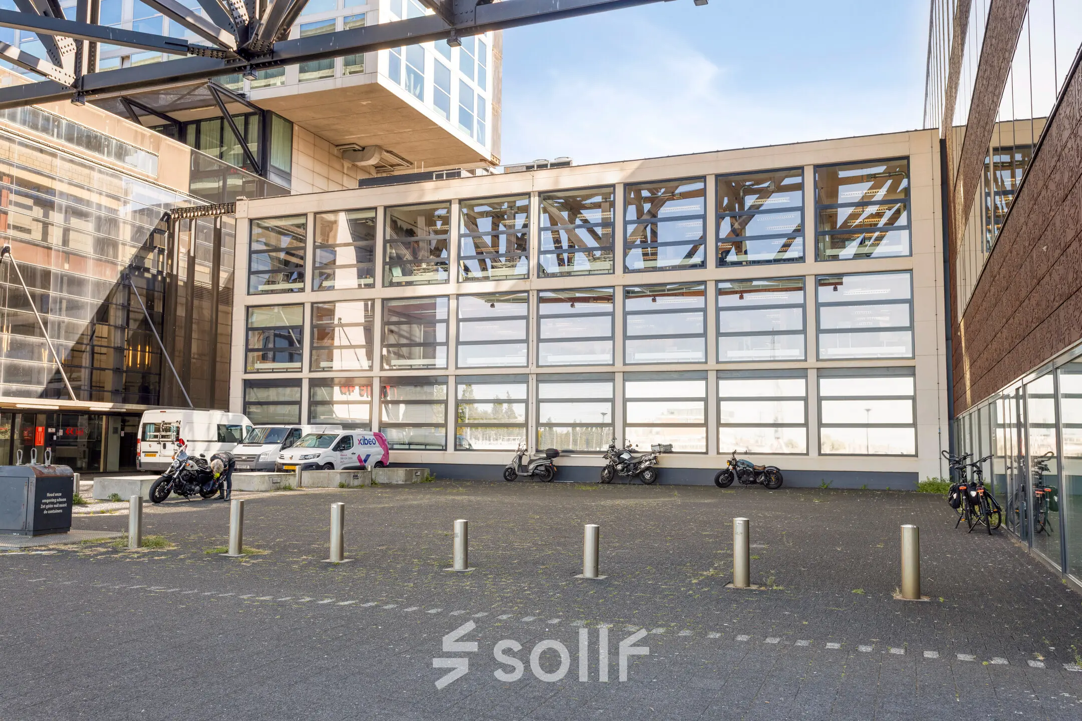 Exterior view of the office building at Lloydstraat 21 B, Rotterdam Delfshaven, featuring a modern facade and parking area. Ideal for office space rental opportunities.