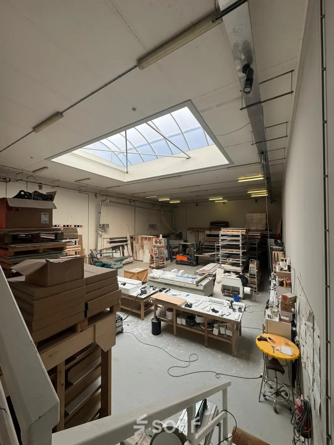 Spacious office space for rent at Van Helmontstraat 17-23 in Rotterdam Delfshaven, featuring a skylight and ample worktable surfaces.