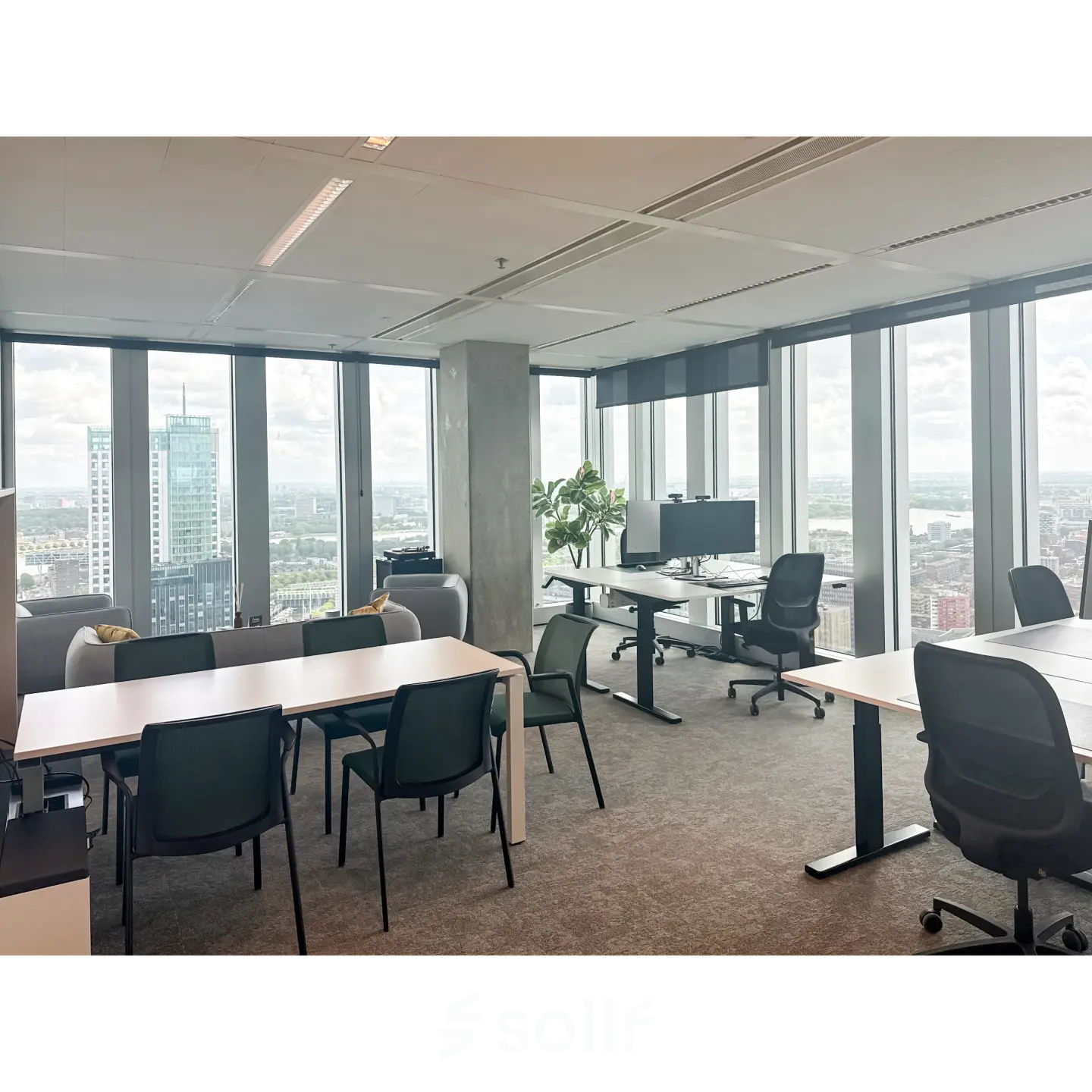 Modern office space at Wilhelminakade 173, Rotterdam Kop van Zuid, featuring large windows and multiple desks, ideal for workspaces. A perfect spot for office space rental with a panoramic city view.