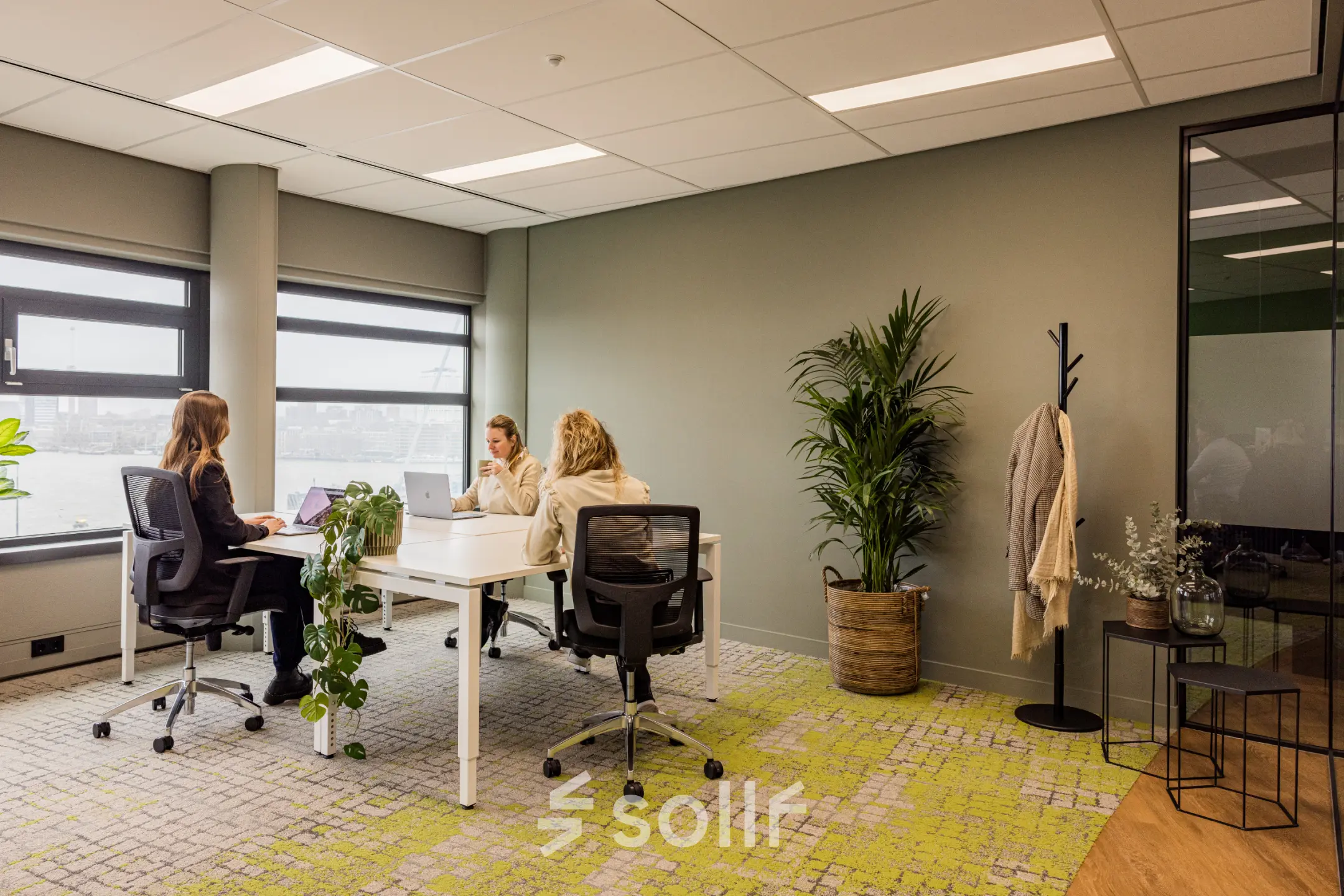 Modern office space at Wilhelminaplein 1-40, Rotterdam Kop van Zuid, featuring a furnished workspace with people engaged in business activities. Ideal for office space rental.