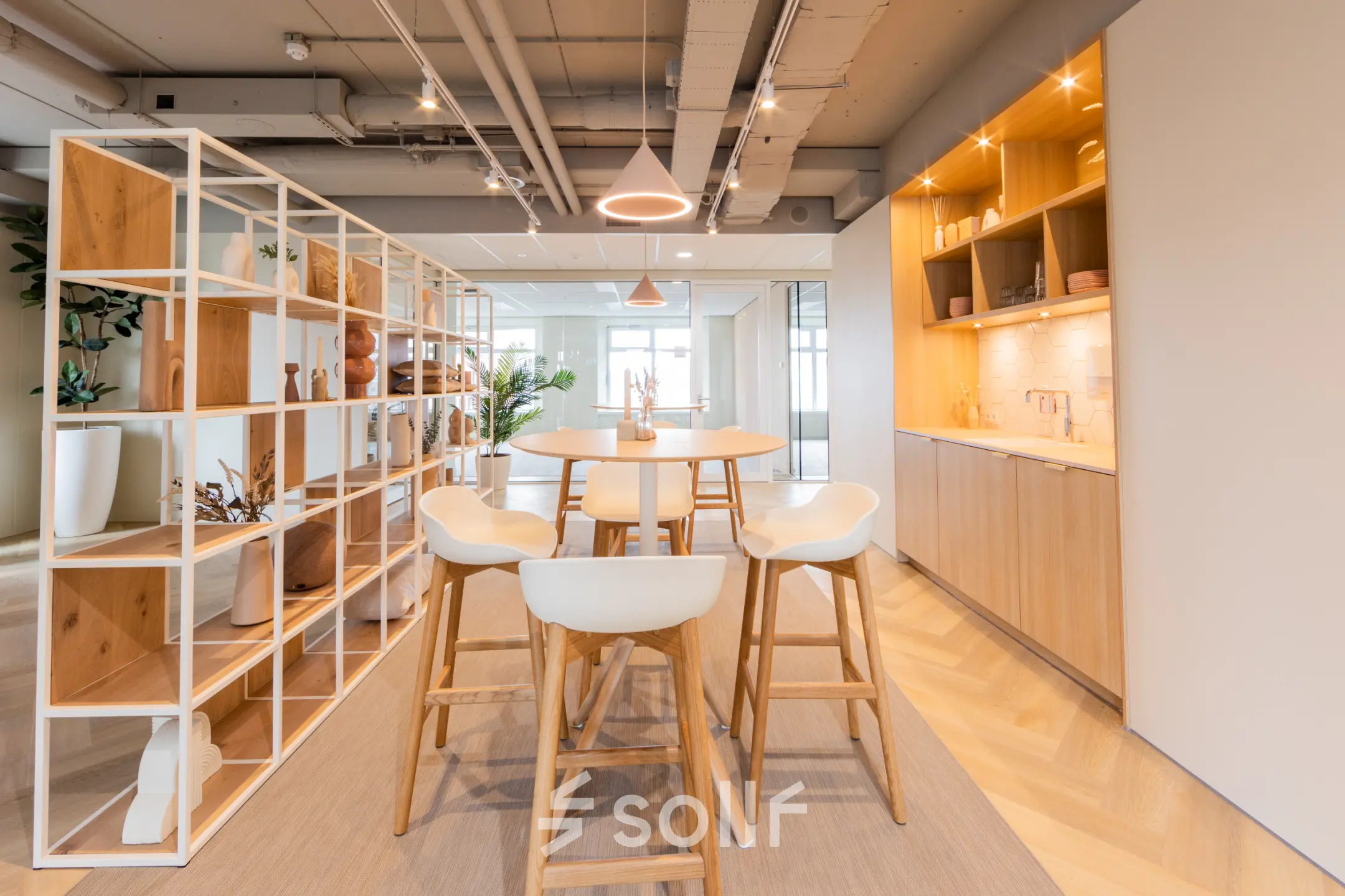 Modern office space at Wilhelminaplein 1-40, Rotterdam Kop van Zuid, featuring a stylish lounge area with wooden furnishings and an open layout for rent.