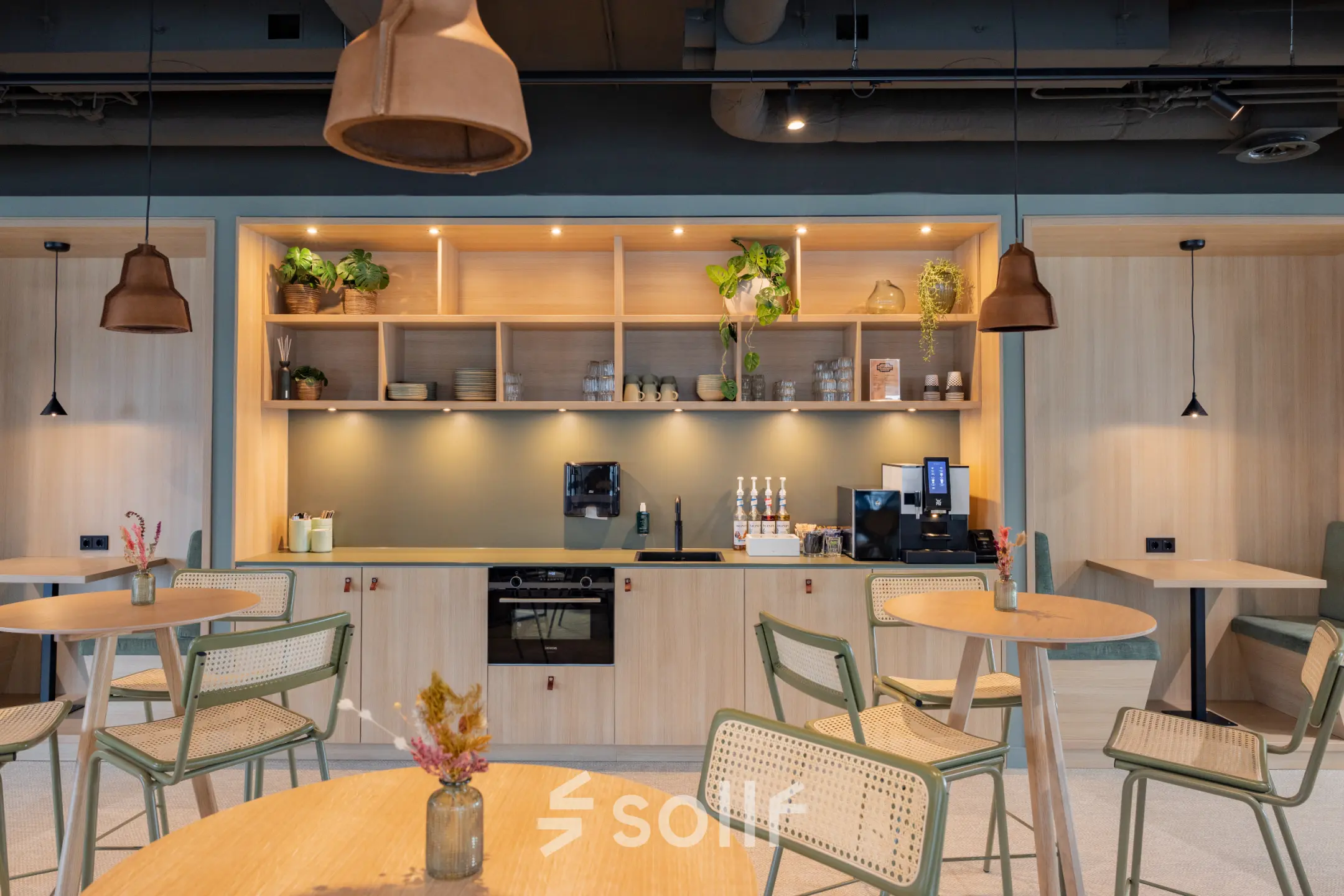 Furnished office space with modern tables and greenery, available for office space rental at Wilhelminaplein 1-40 in Rotterdam Kop van Zuid.