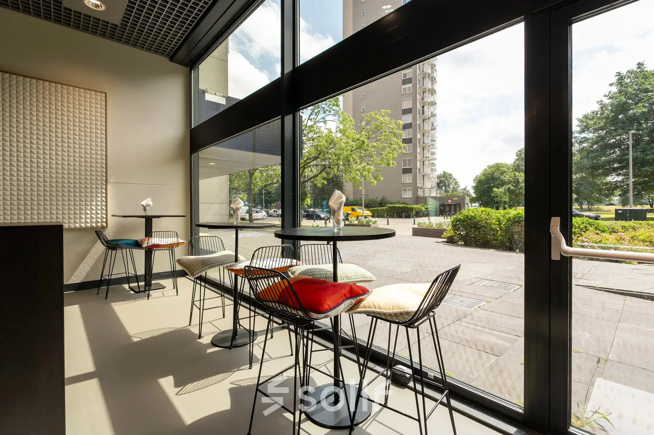 Bright office space with high windows and modern chairs at Oostmaaslaan 71, perfect for office space rental in Rotterdam Kralingen.