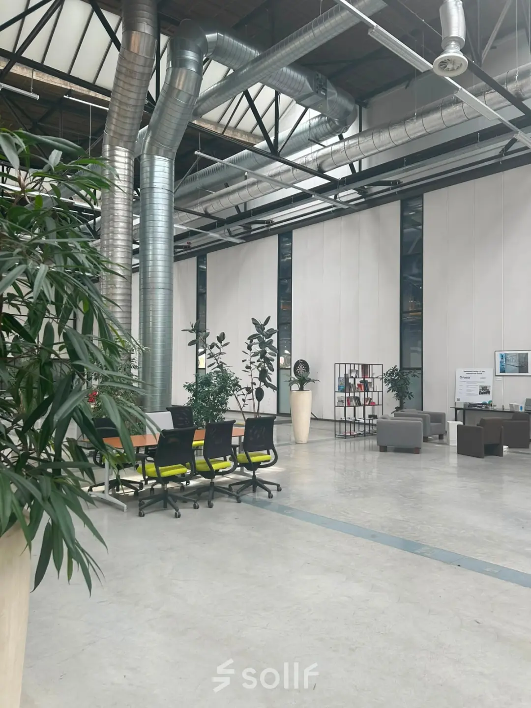 Spacious and modern office space at Scheepsbouwweg 29, featuring high ceilings, ample seating, and greenery, perfect for office space rental in Rotterdam Waalhaven.