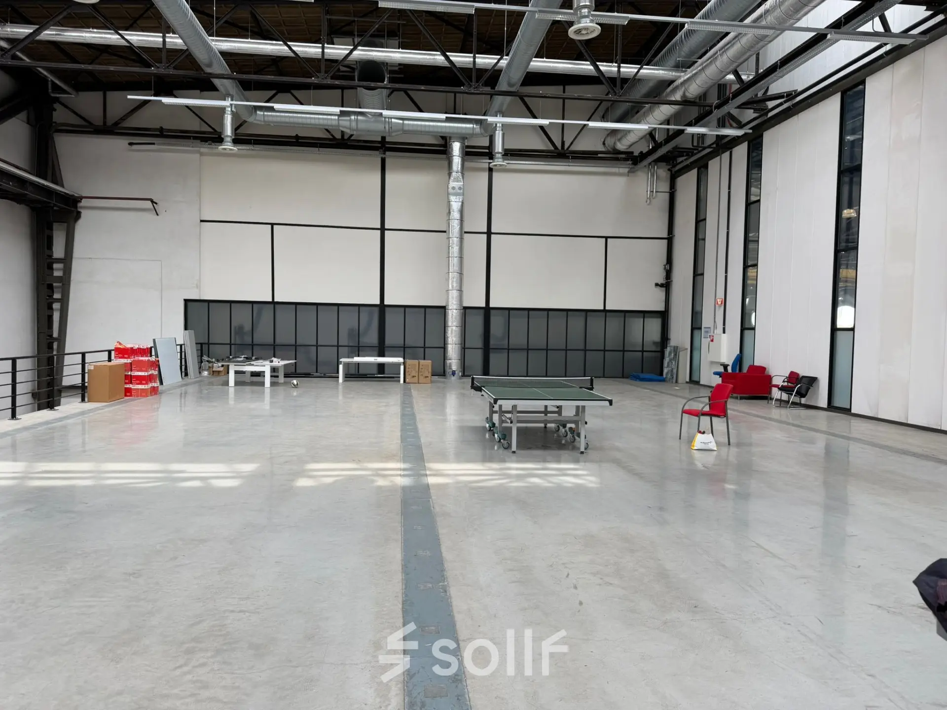 Spacious office area available for rent in Rotterdam Waalhaven, featuring high ceilings, large windows, and minimal furnishings, ideal for versatile workspace configurations.