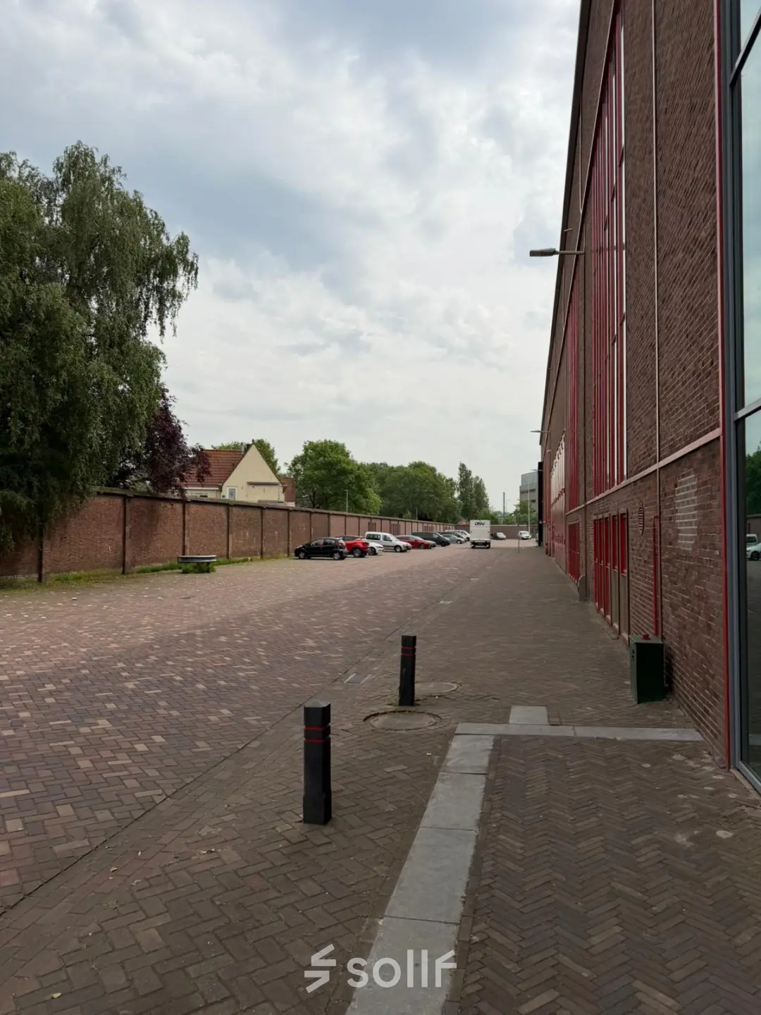 Exterior view of Scheepsbouwweg 29 in Rotterdam Waalhaven, featuring a street scene with cars parked along the side.