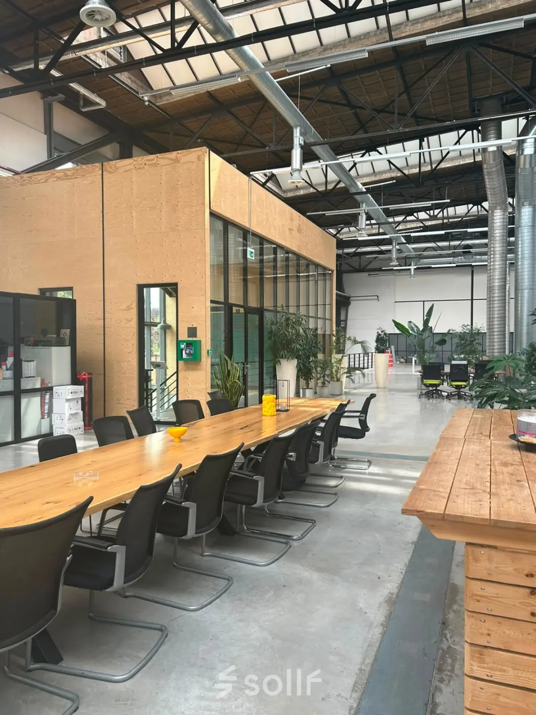 Spacious industrial-style interior at Scheepsbouwweg 29, Rotterdam Waalhaven, featuring a long wooden table and chairs suitable for collaborative work. Ideal for office space rental.