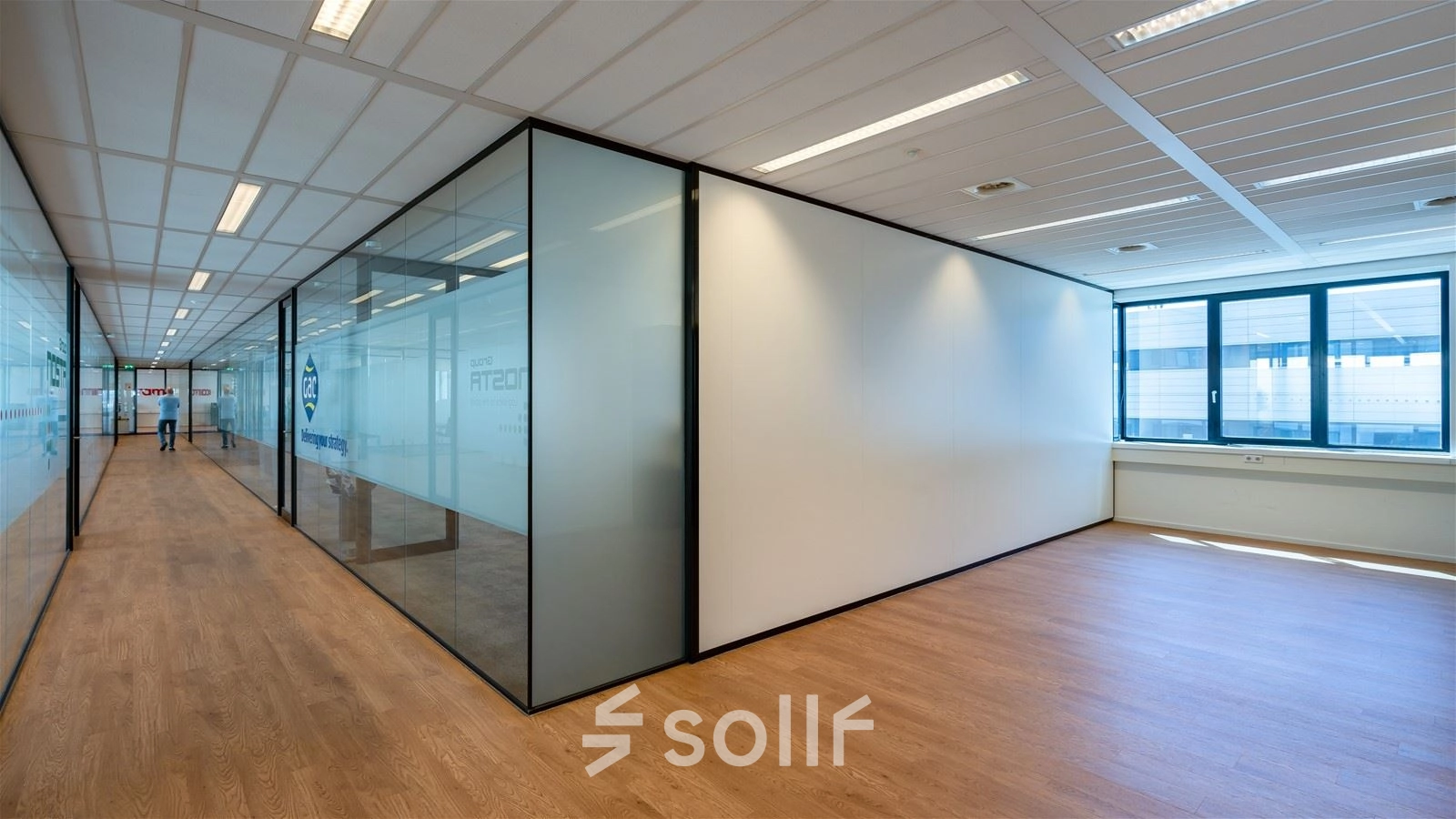 Bright office space at Waalhaven O.z. 83 in Rotterdam featuring glass-walled rooms and wooden flooring, suitable for office space rental.