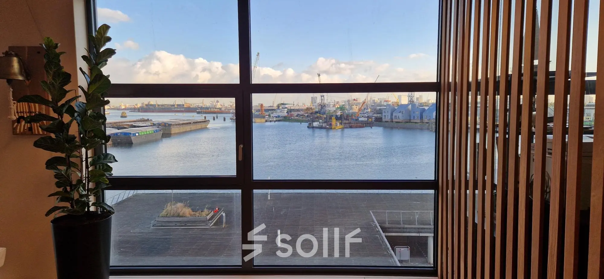 Bright office view of the Rotterdam Waalhaven port through large windows, ideal for those seeking office space rental with a scenic backdrop.