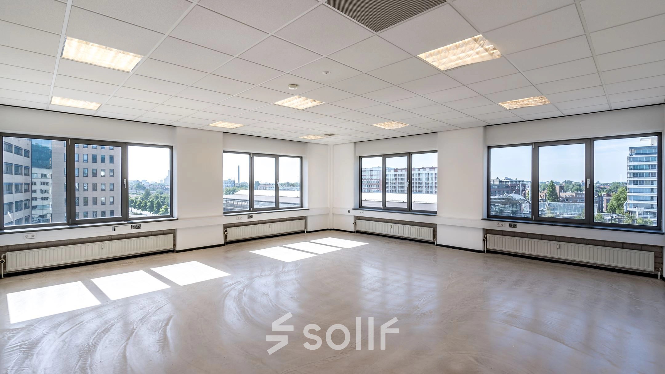 Spacious, naturally lit office space for rent at Overschieseweg 304-332 in Schiedam, featuring large windows and city views, ideal for creating a productive work environment.