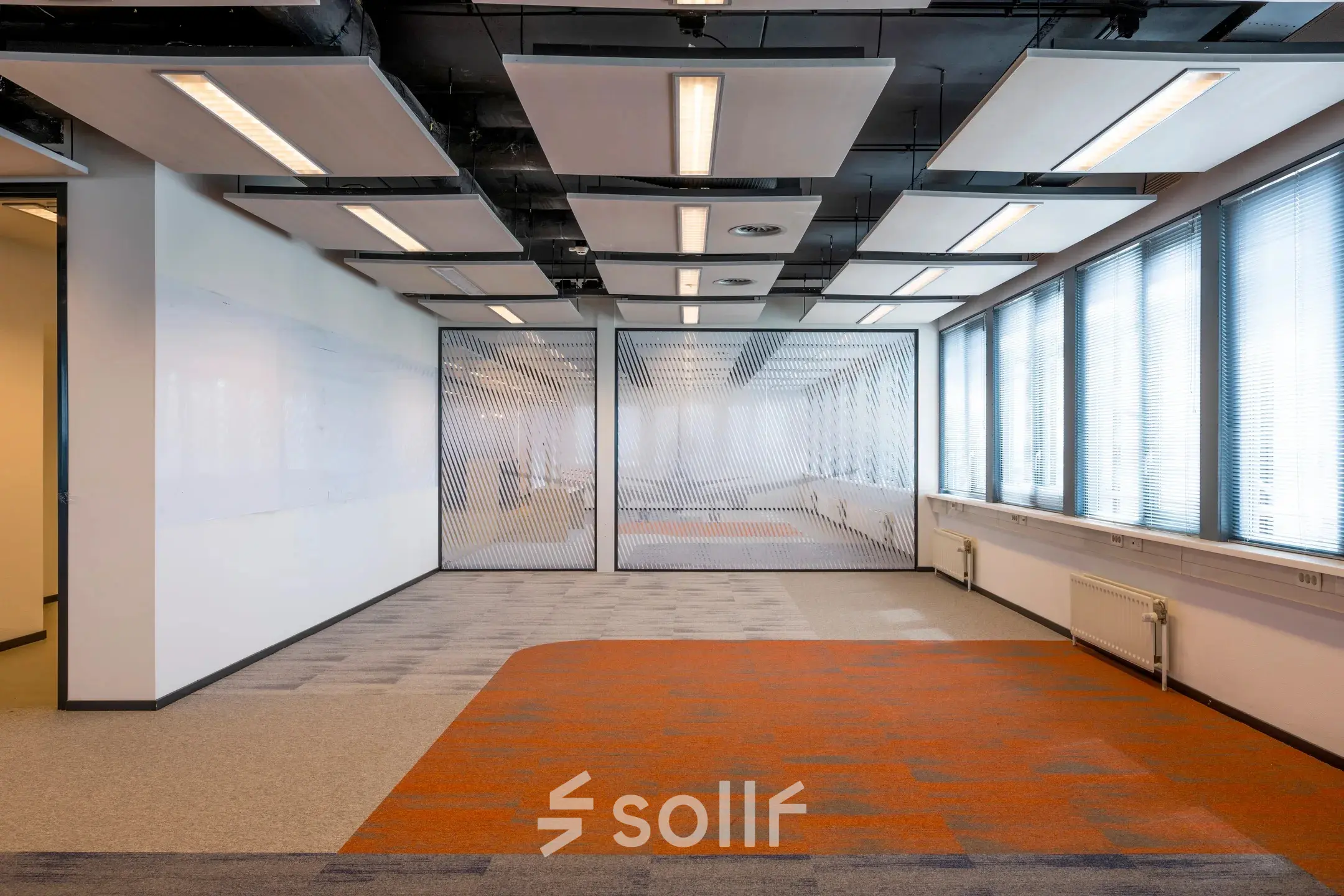 Spacious office for rent at Schiphol Airport with unique ceiling design and vibrant flooring, ideal for office space rental.