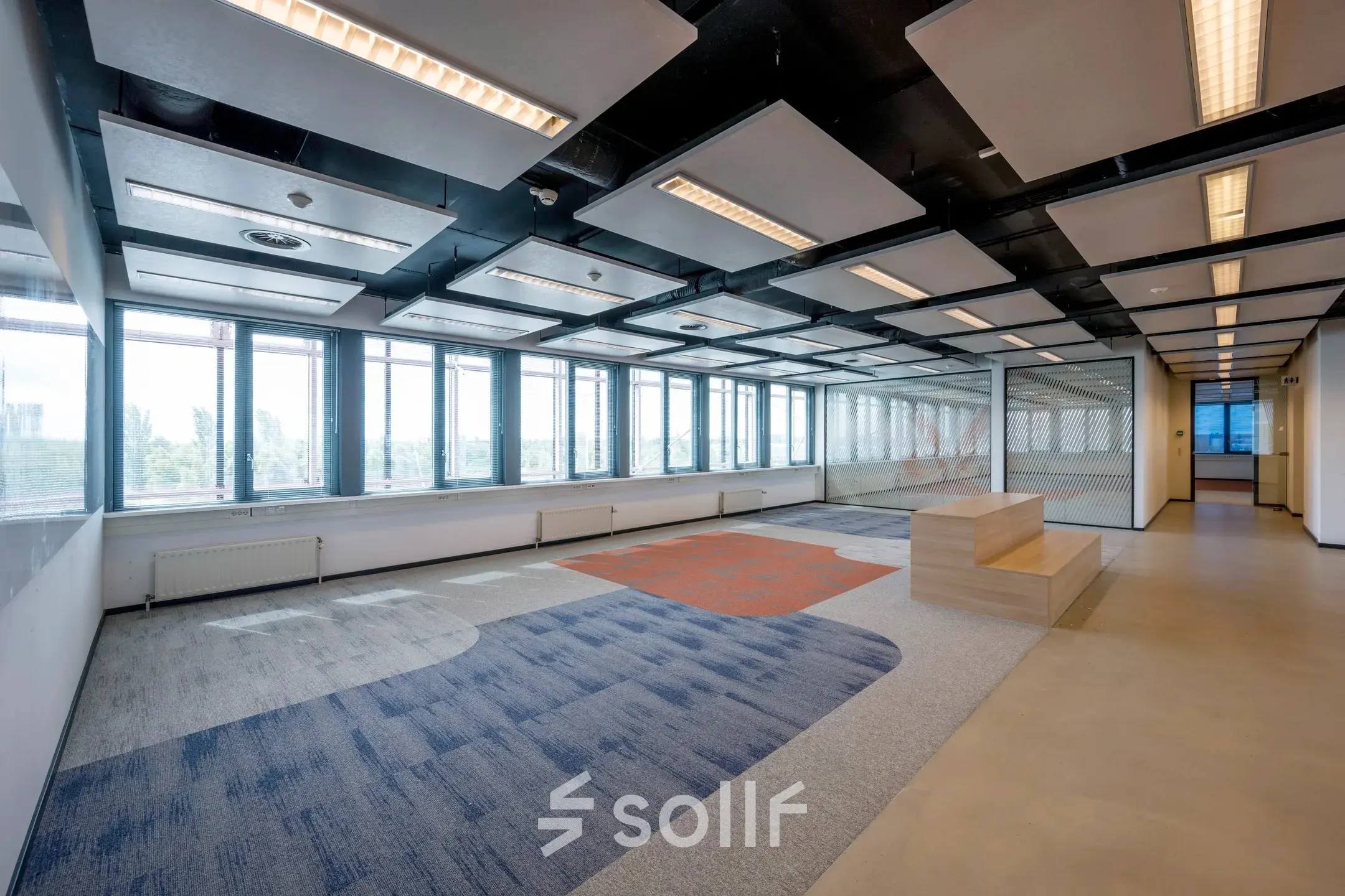 Spacious office area with modern lighting and large windows offering a panoramic view, ideal for office space rental at Schiphol Airport.