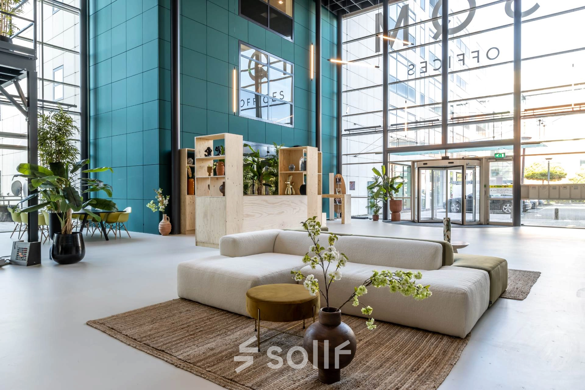Spacious office lobby with modern furnishings, plants, and large windows at Beechavenue 54-100, Schiphol Rijk. Ideal for those looking to rent office space with a bright, welcoming ambiance.