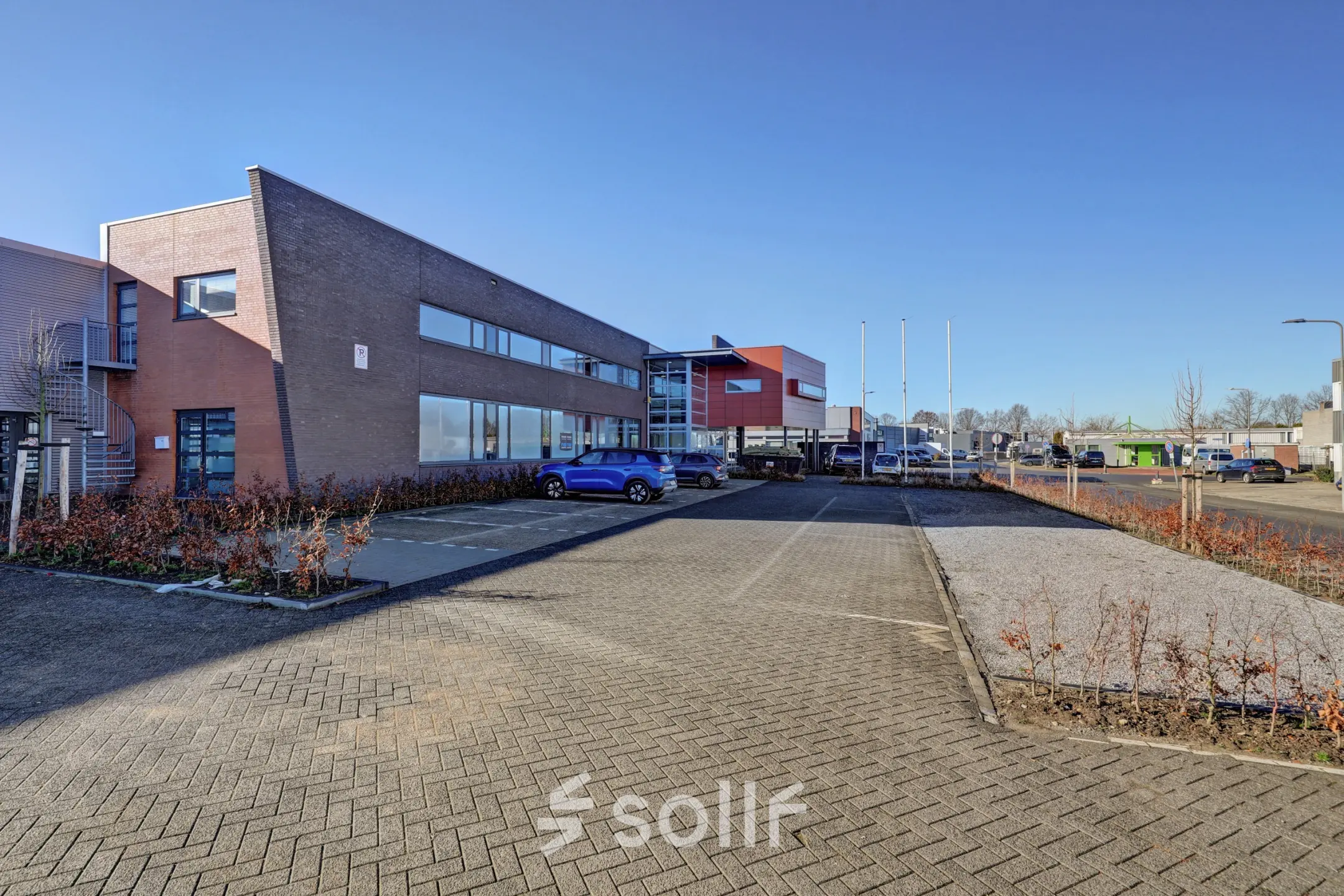 Exterior view of an office to rent at Fischerpad 106, Sittard, featuring a spacious parking area in front of the building.