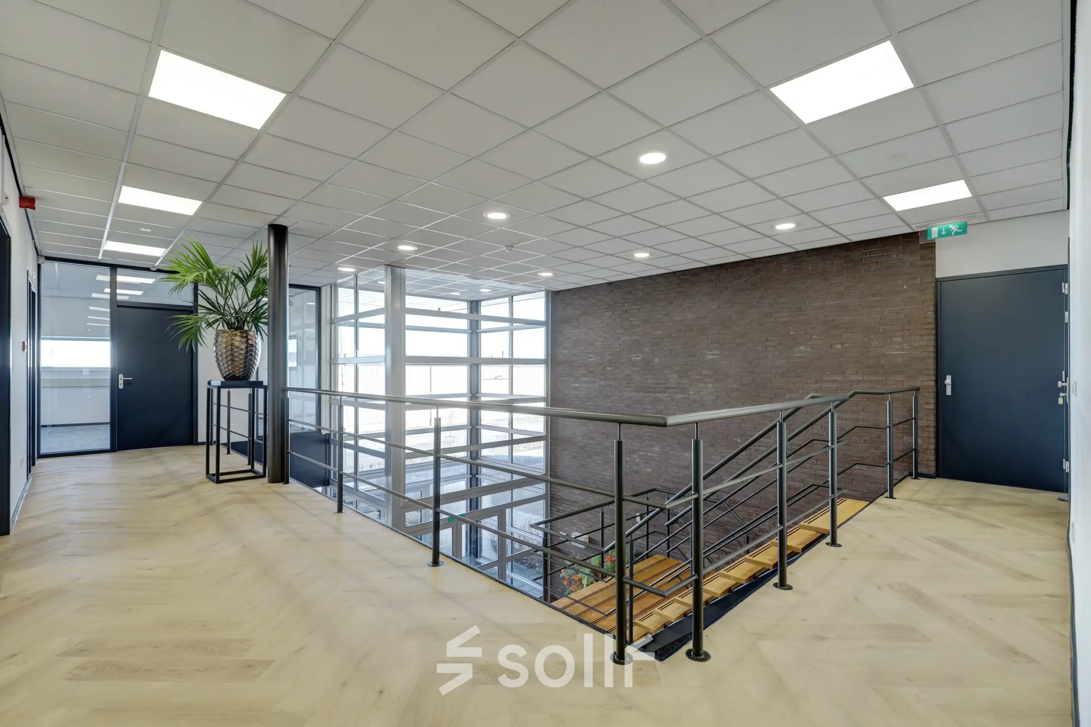 Bright and spacious hallway at Fischerpad 106, Sittard, available for office space rental, featuring a modern design with natural light and stylish railing.