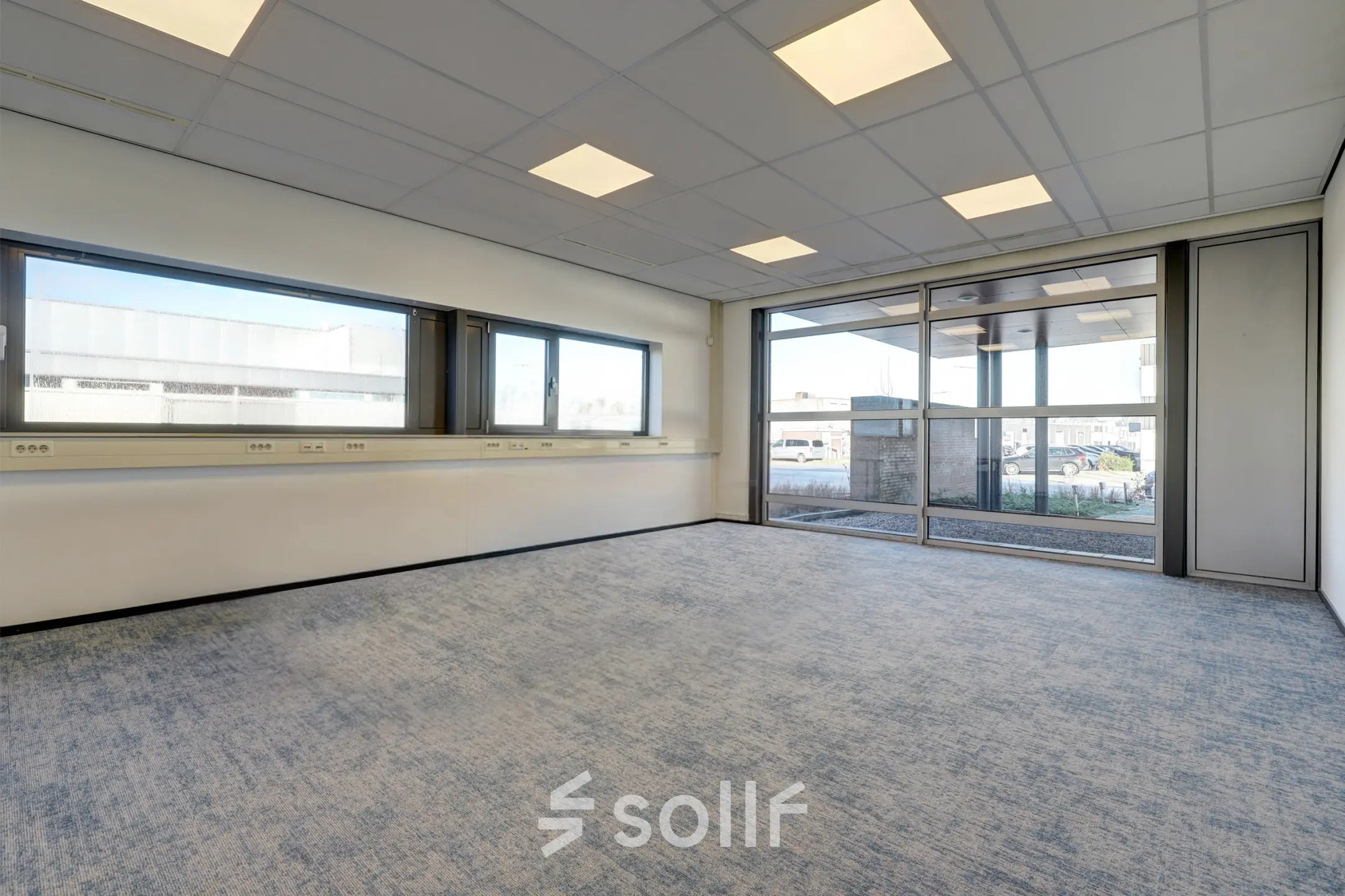 Bright office space for rent at Fischerpad 106 in Sittard, featuring large windows for natural light and ample electrical outlets.