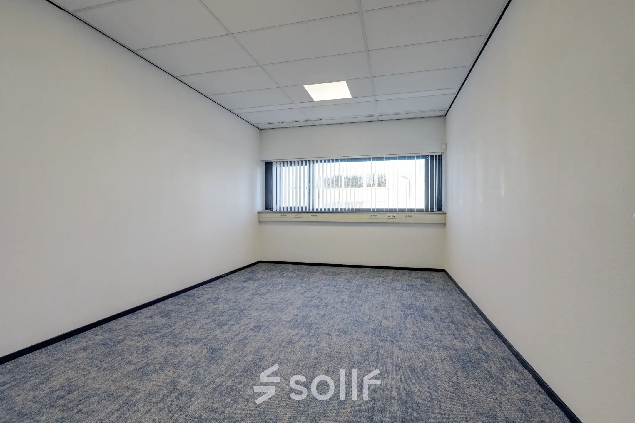 Empty office space at Fischerpad 106, Sittard, with light carpeting and a large window. Ideal for office space rental.