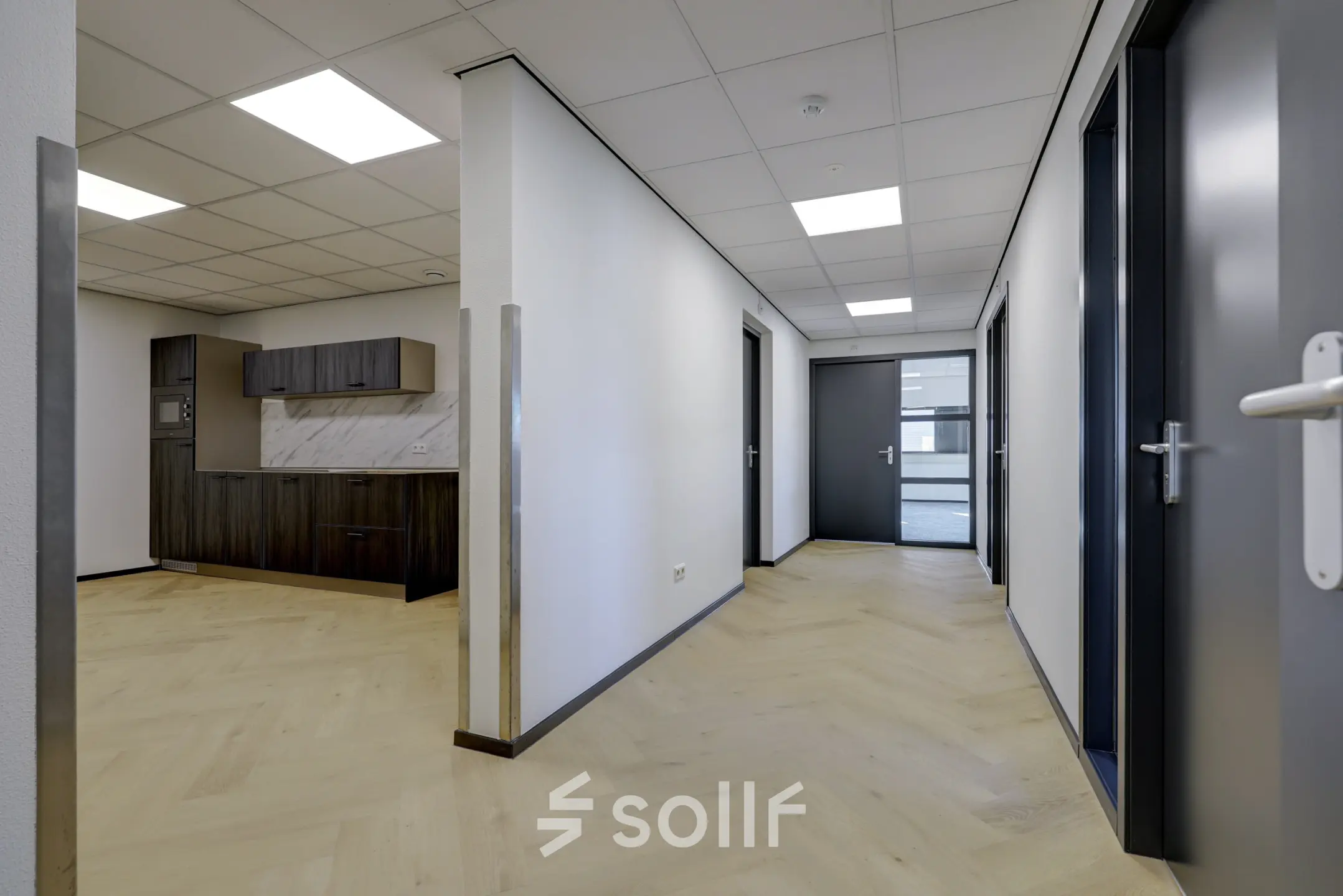 Spacious hallway in an office space suitable for rent, featuring light wooden floors and modern fittings at Fischerpad 106, Sittard.