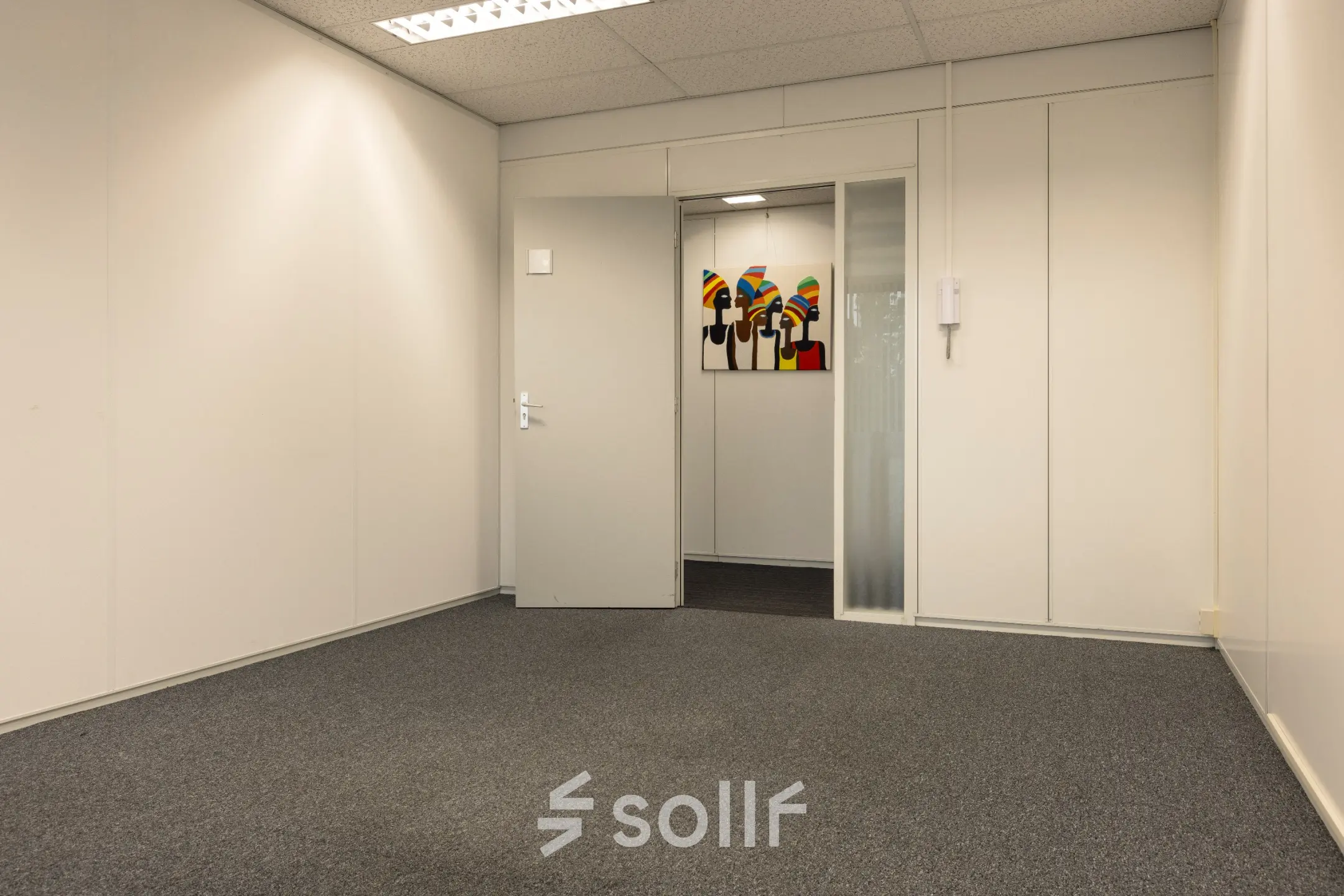 Interior view of an empty office space at Curieweg 9 in Spijkenisse, suitable for rent, featuring neutral walls and carpeting.