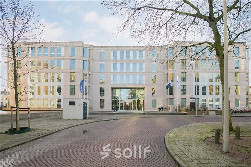 Exterior view of the Alexanderveld 5-9 office building in The Hague Center featuring a modern facade with large windows and a welcoming entrance, ideal for office space rental.