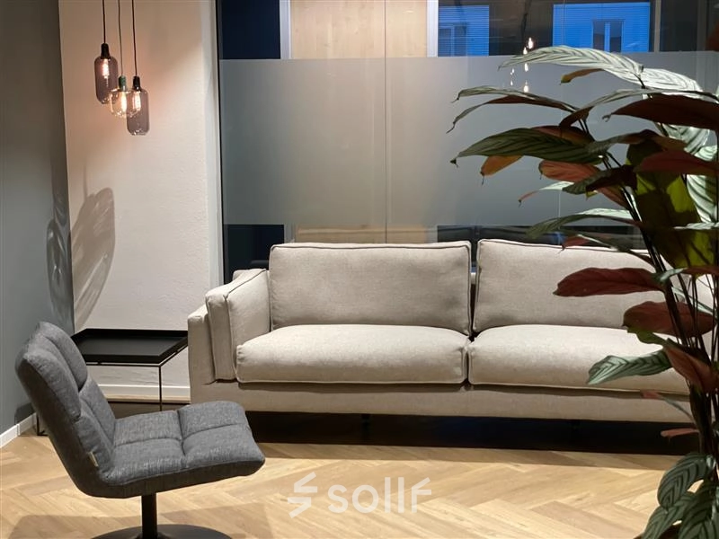 Modern office lounge at Alexanderveld 5-9, The Hague Center, featuring chic seating and warm lighting, ideal for office space rental.