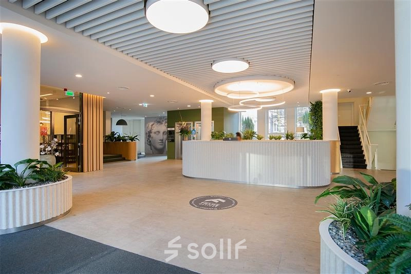 Spacious reception area at Alexanderveld 5-9, The Hague Center featuring modern lighting and greenery. Ideal for a professional office space rental.