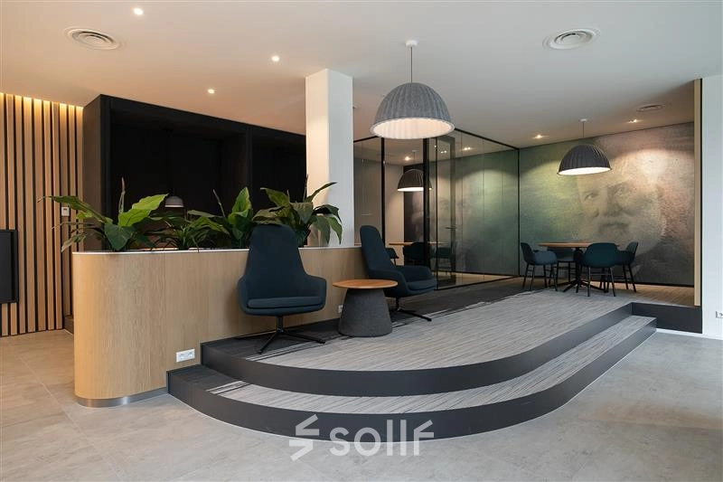 Modern office interior at Alexanderveld 5-9, The Hague Center featuring stylish furnishings and a meeting area, ideal for office space rental.