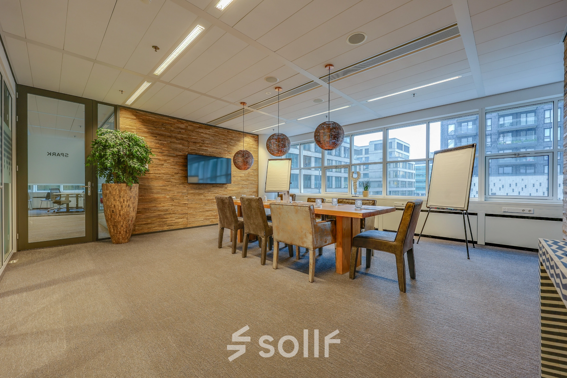 Spacious, well-lit conference room with a large wooden table and chairs, suitable for office space rental in The Hague Center.