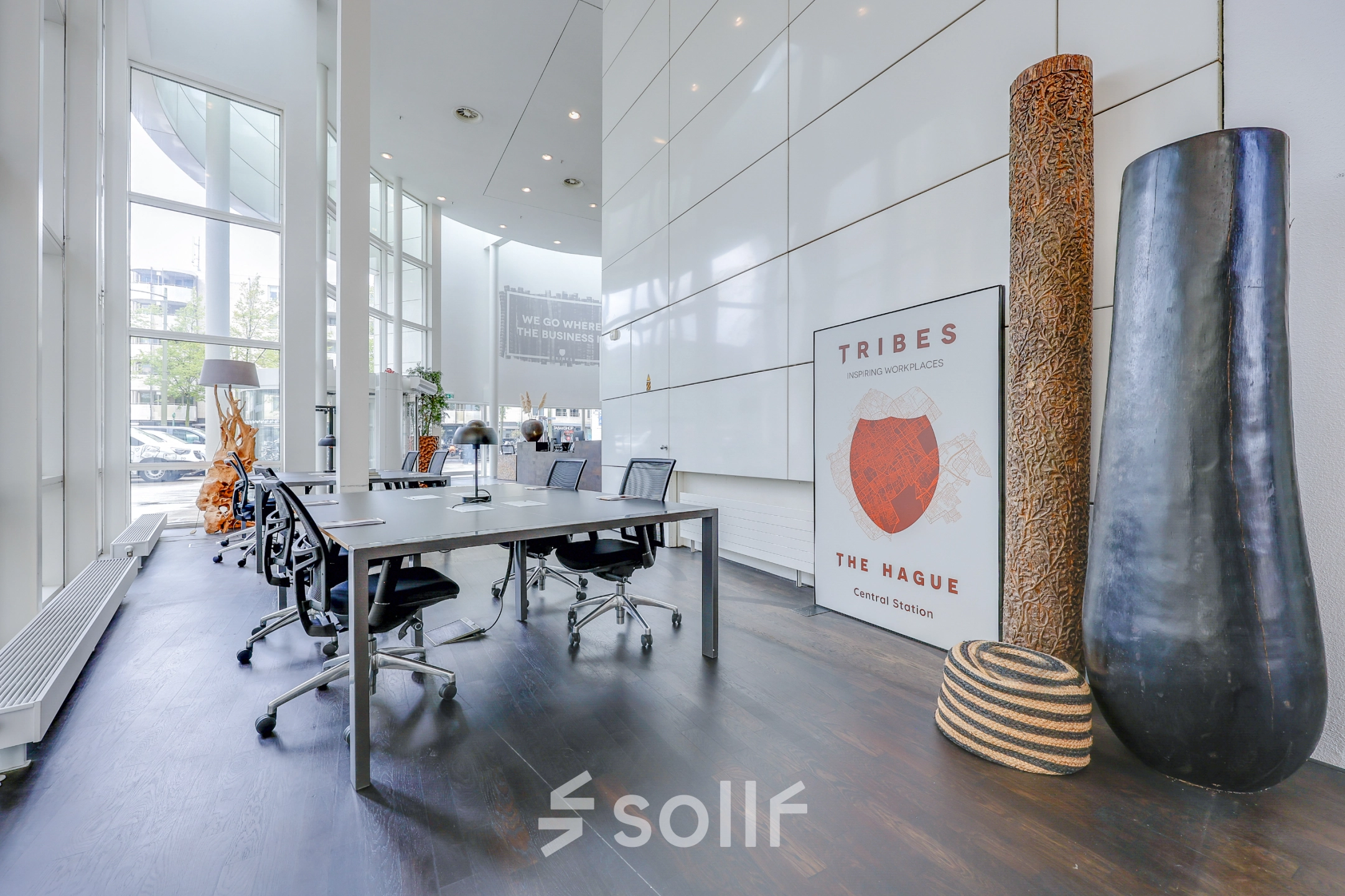 Spacious office to rent at Kalvermarkt 53, The Hague Center, featuring a modern interior with tables, chairs, and large windows.