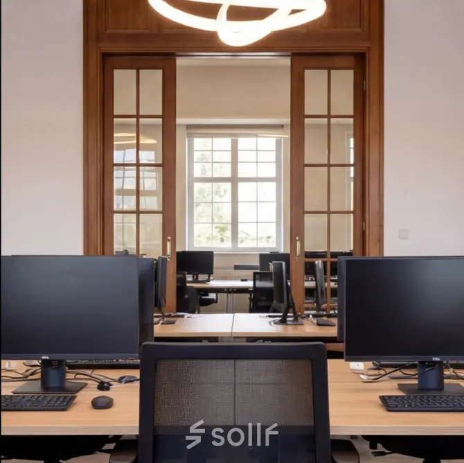 Modern office space rental with ample desks and computers, located at Mauritskade 9 in The Hague Center.