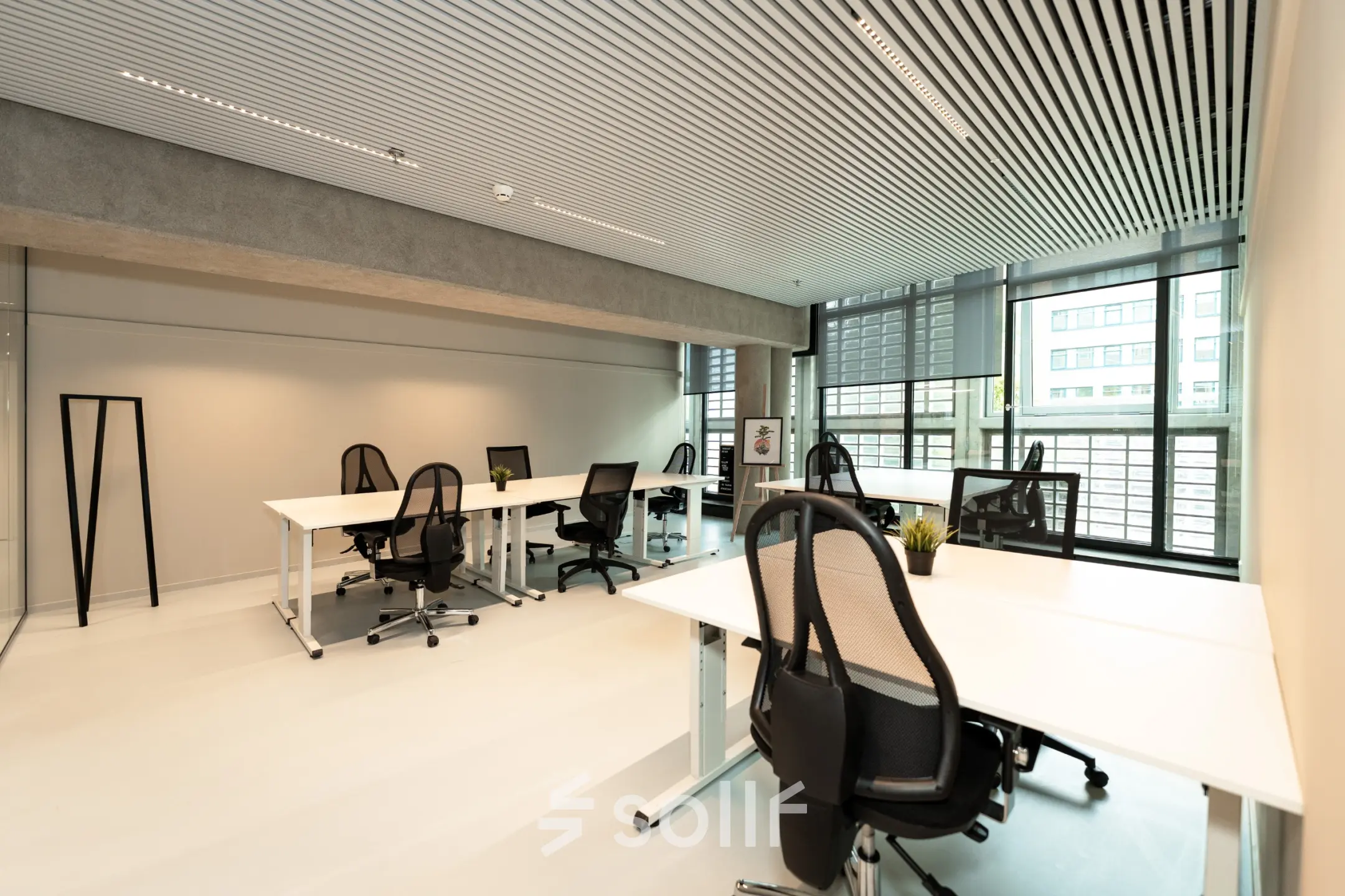 Office space for rent at Waldopstraat 5, The Hague Center featuring modern workstations with ergonomic chairs and computers.