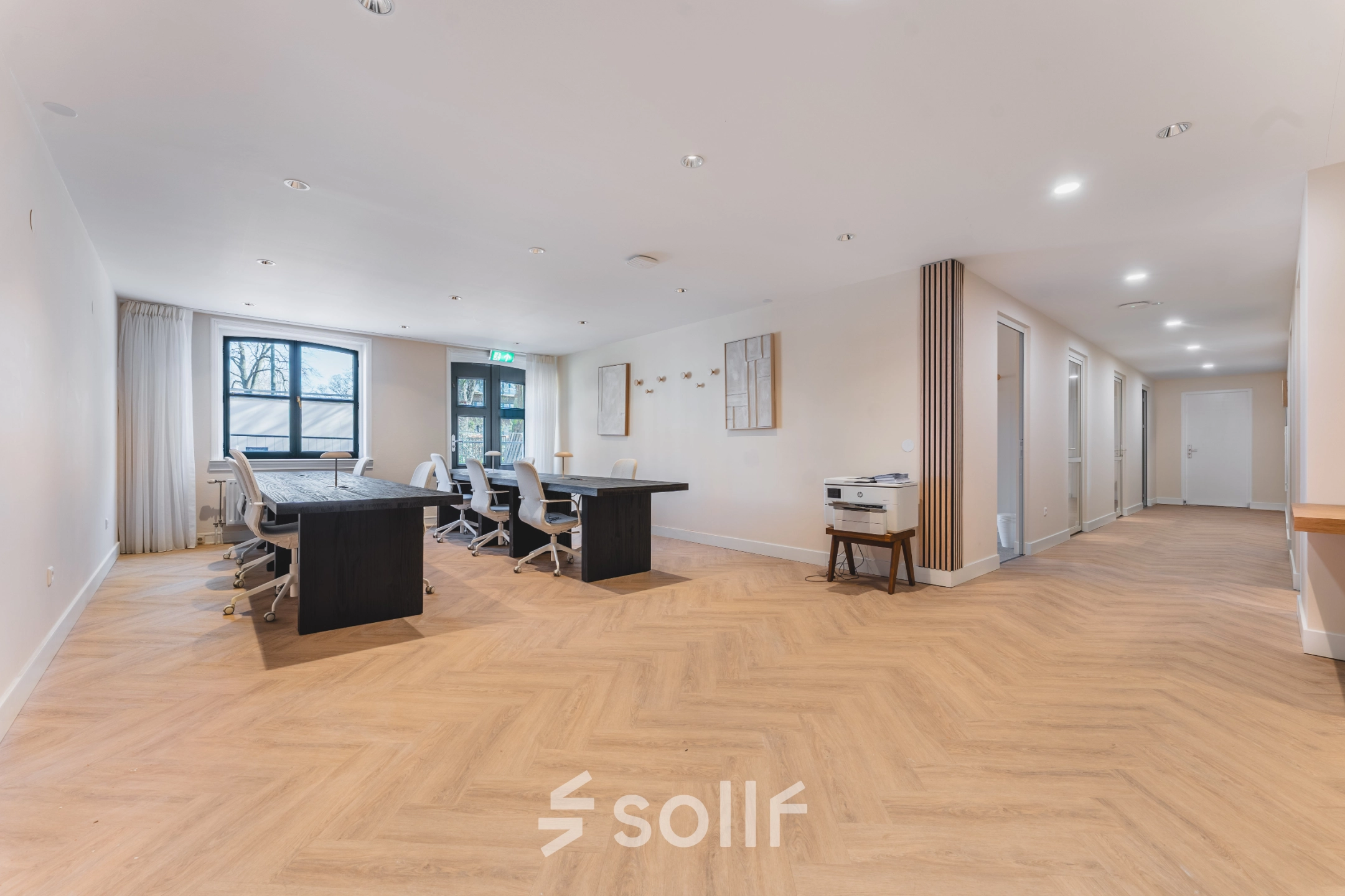 Spacious office with modern furnishings including several desks and chairs at Zeestraat 100, The Hague Center, ideal for office space rental.