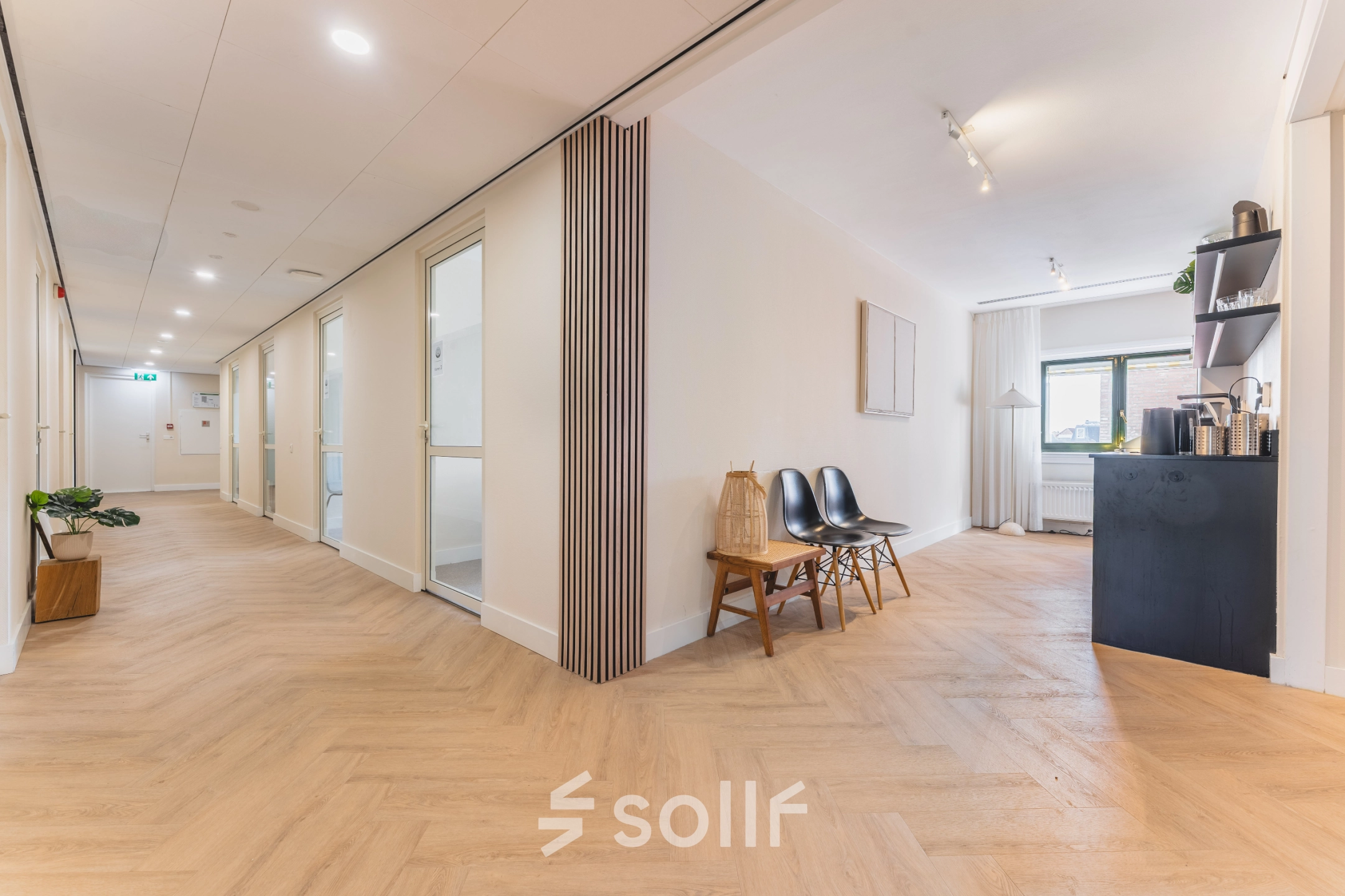 Bright office space at Zeestraat 100, The Hague Center available for rent, featuring stylish seating and a small refreshment area.