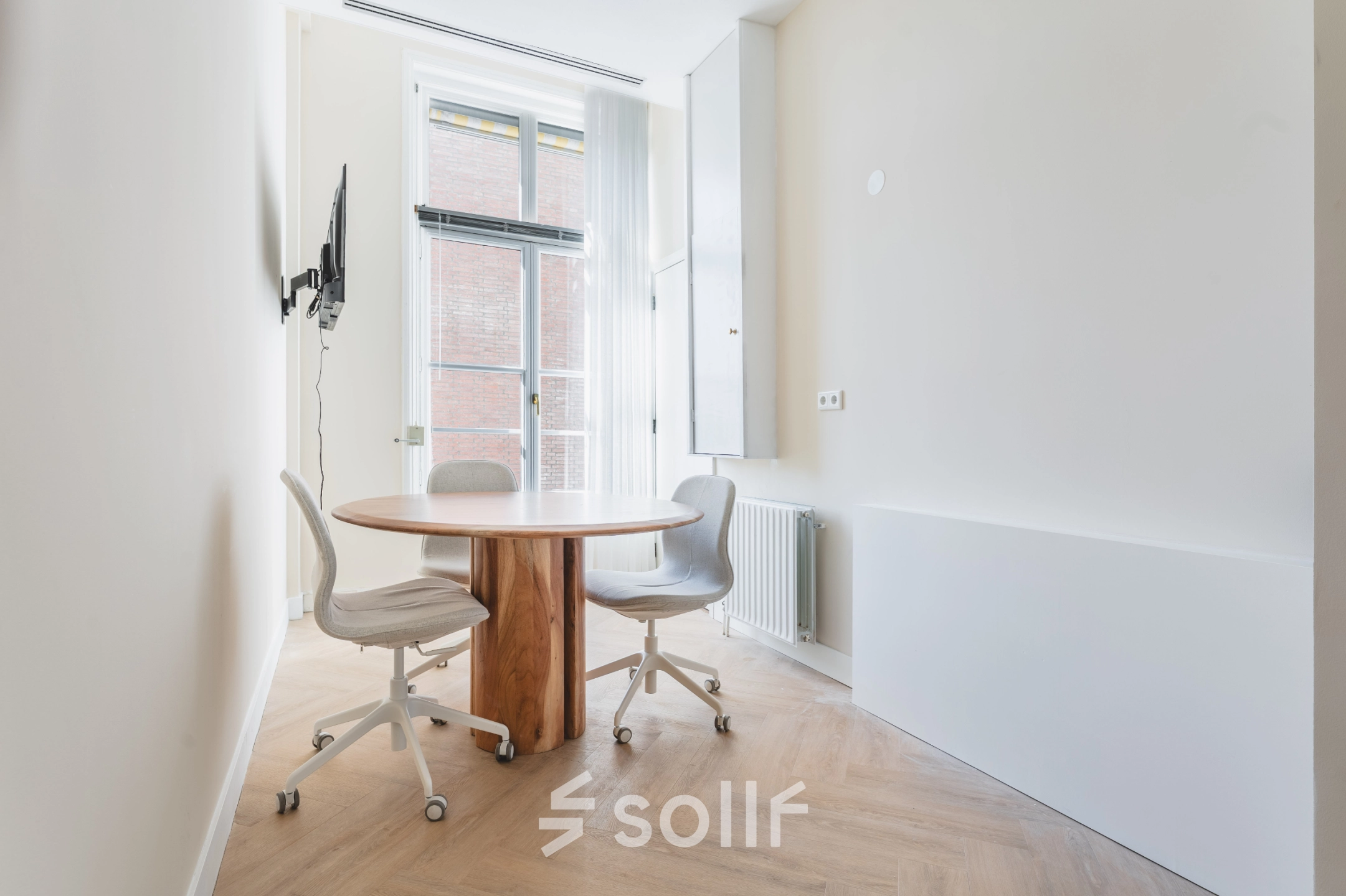 Bright office space with a round table and chairs at Zeestraat 100, The Hague Center, ideal for rental.