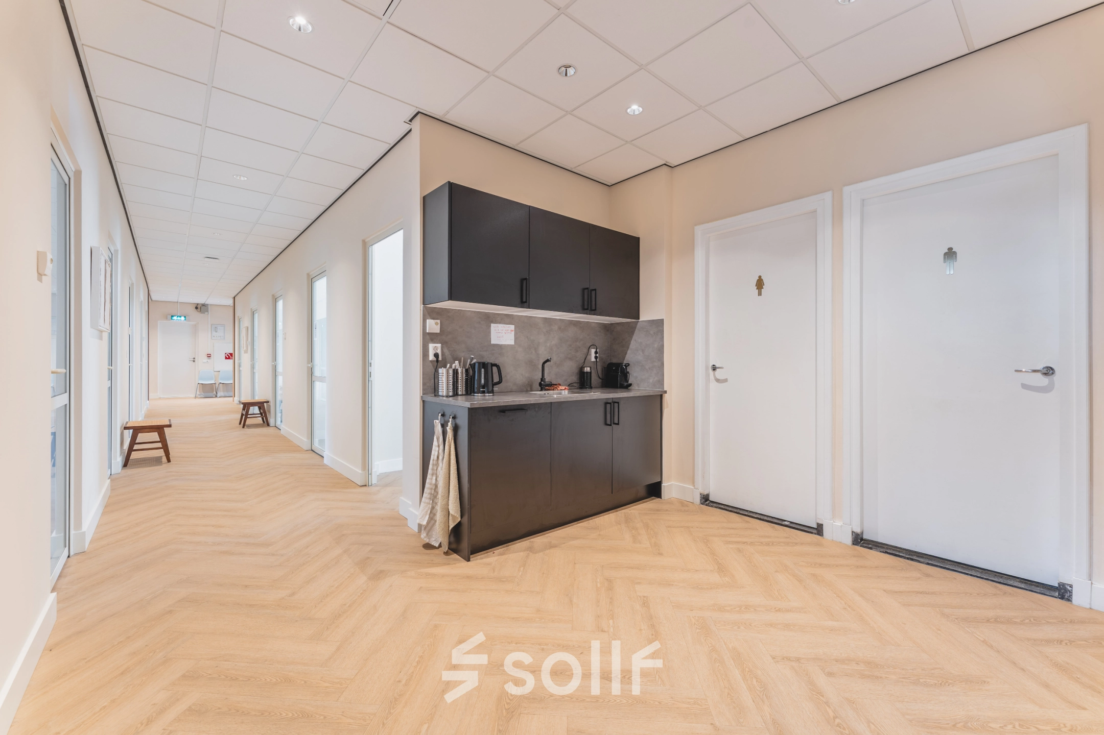 Bright office space with a kitchenette in Zeestraat 100, The Hague Center, available for rent. The corridor leads to various rooms, ideal for any office space rental needs.