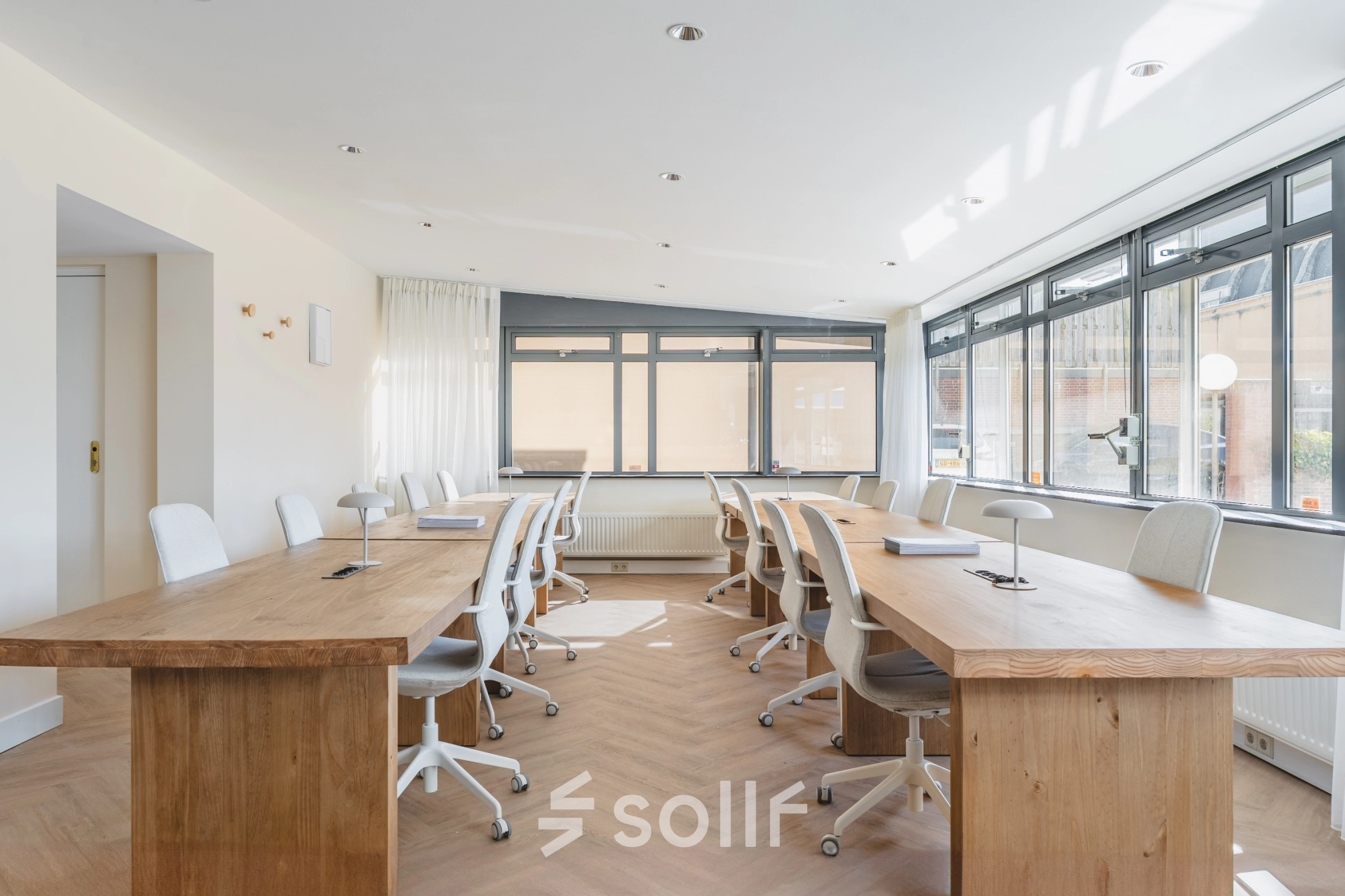 Bright office space with wooden desks and chairs, available for office space rental at Zeestraat 100 in The Hague Center.